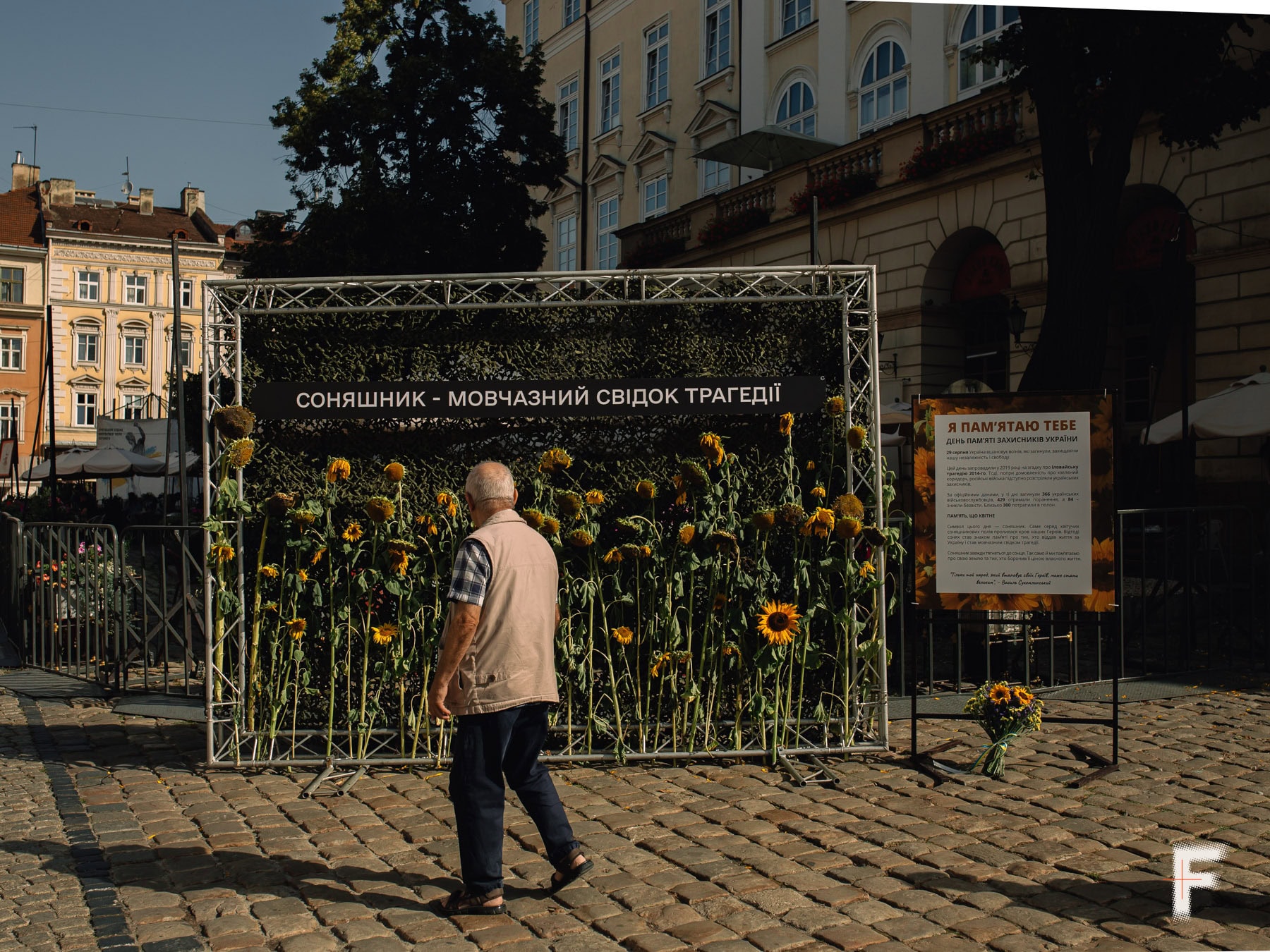 Чоловік проходить між меморіалами з соняшниками