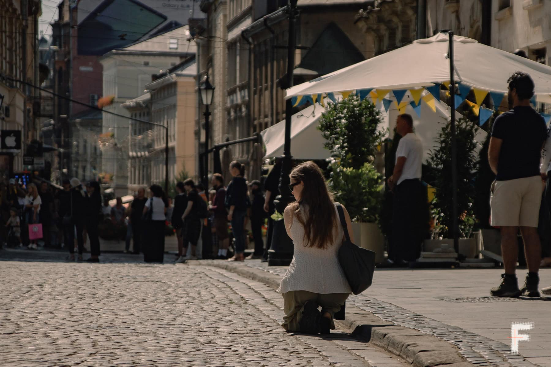 Площа у Львові, жінка стоїть на колінах