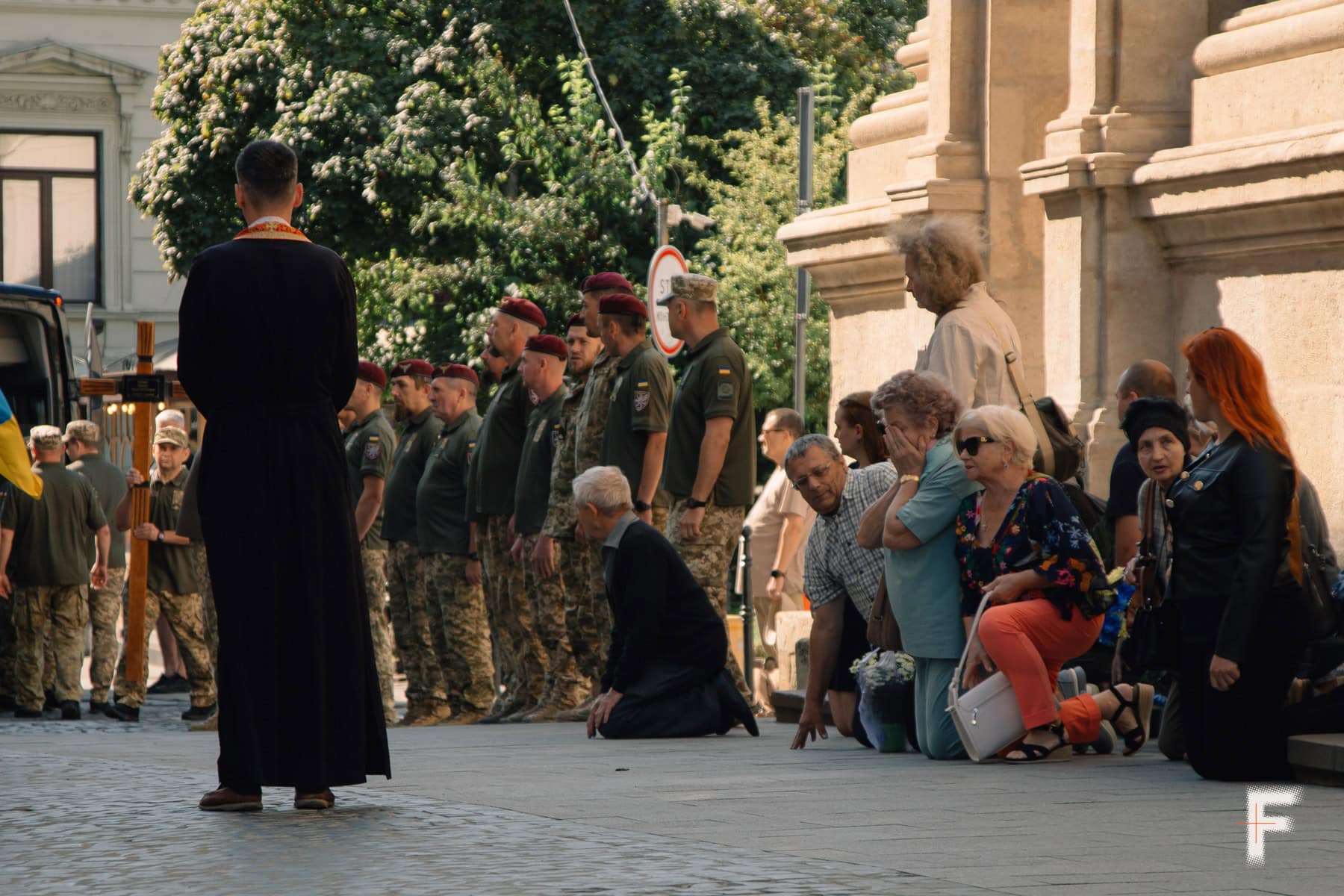 Люди стоять на колінах біля церкви