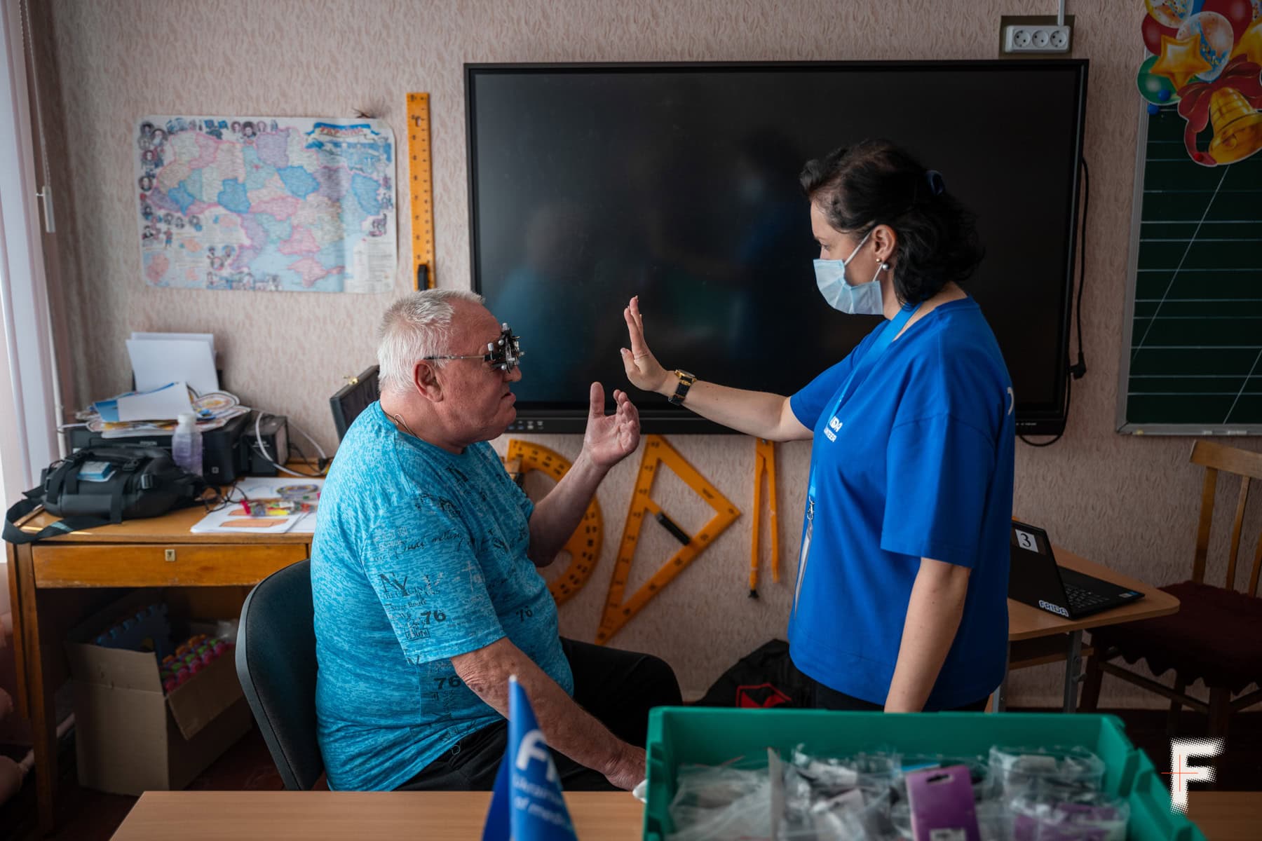 Офтальмолог жінка проводить огляд літнього пацієнта.