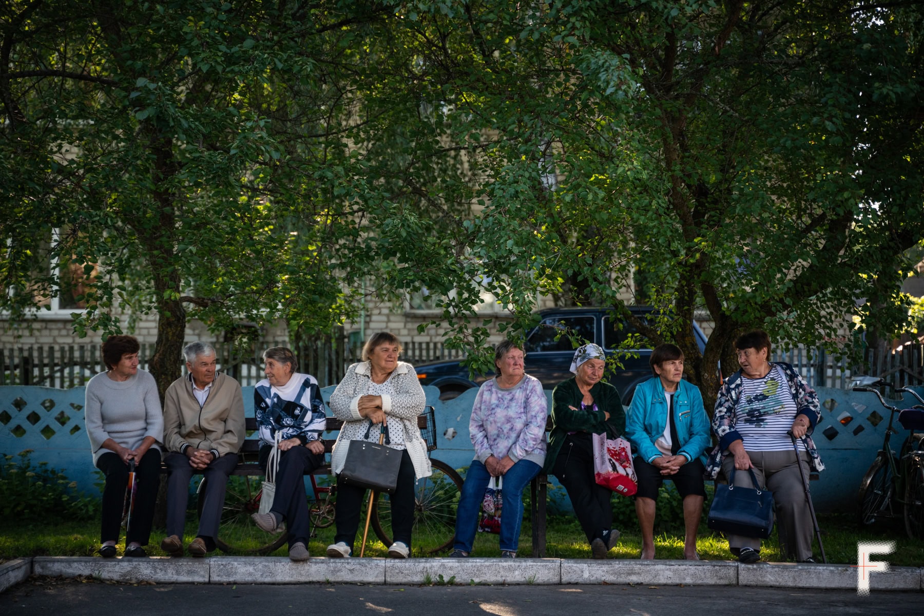 Літні пацієнти чекають у черзі на прийом просто неба.