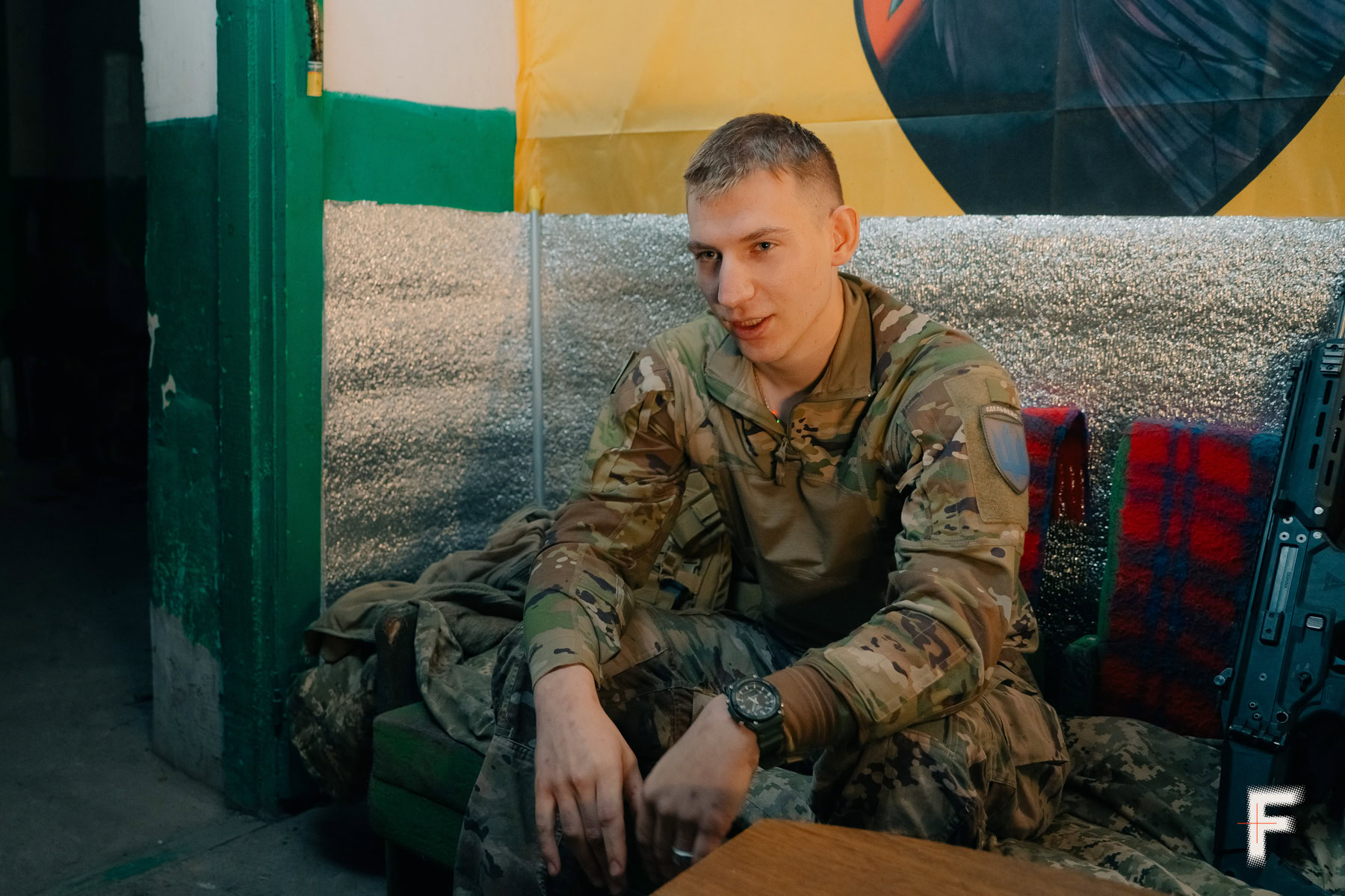 Чоловік у військовій формі сидить на дивані