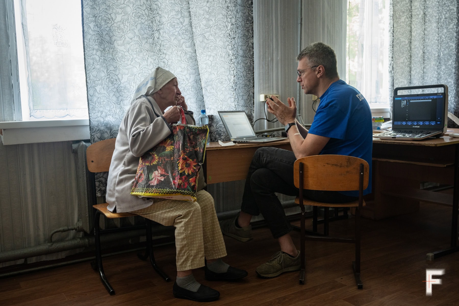 Літня жінка на прийомі у волонтера-лікаря.