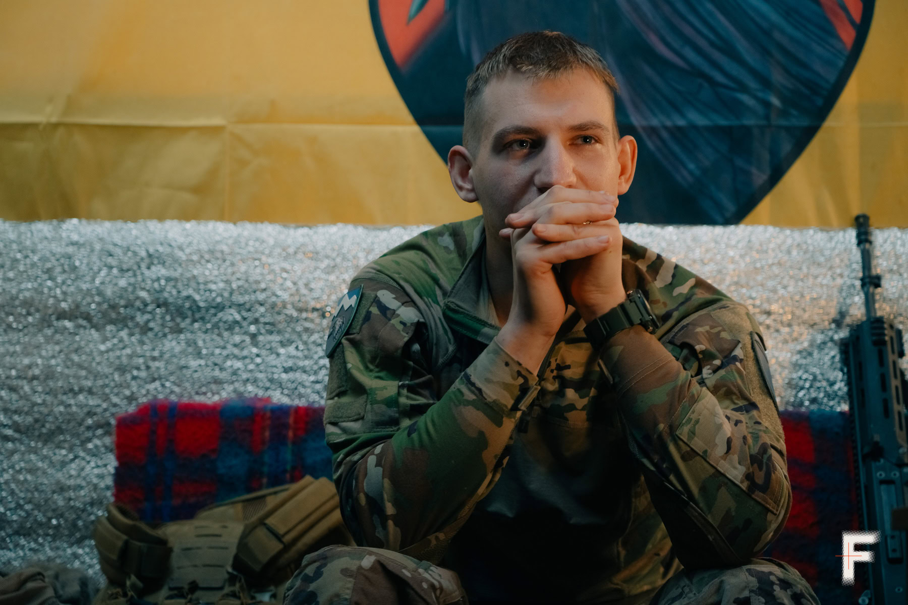 Військовий чоловік тримає руки разом біля голови