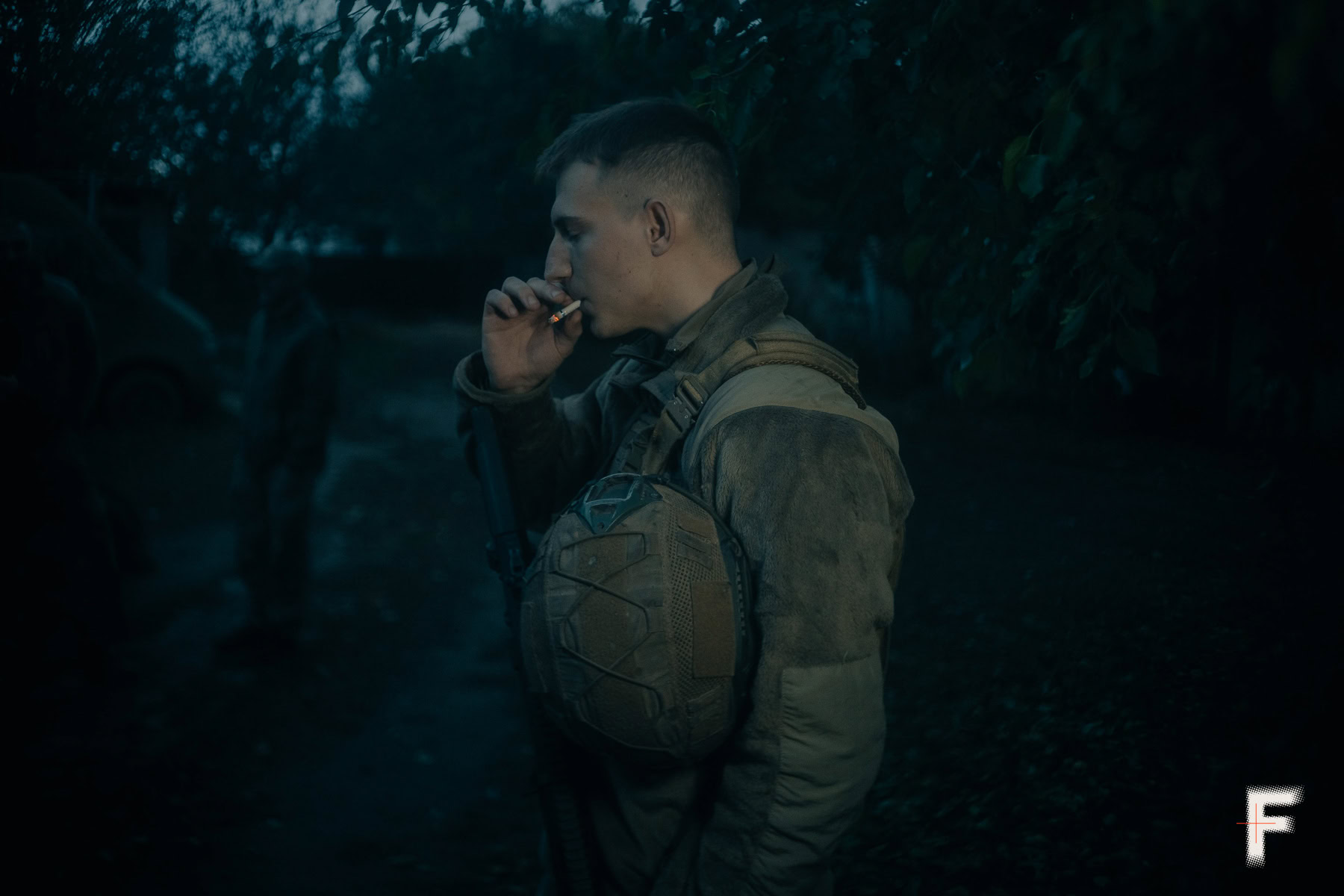 Військовий чоловік на вулиці курить цигарку