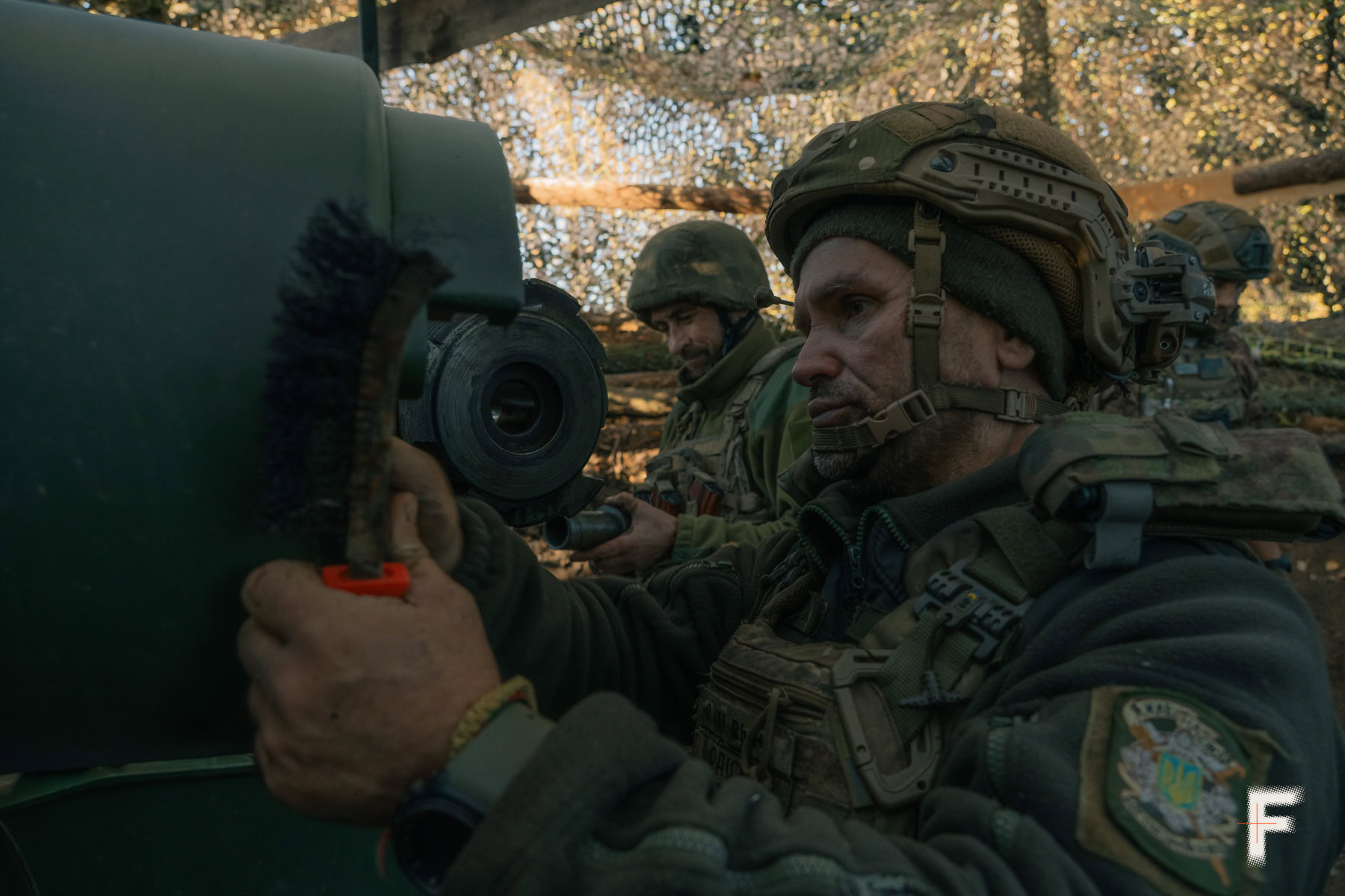 Українські артилеристи обслуговують і чистять гармату після бою.