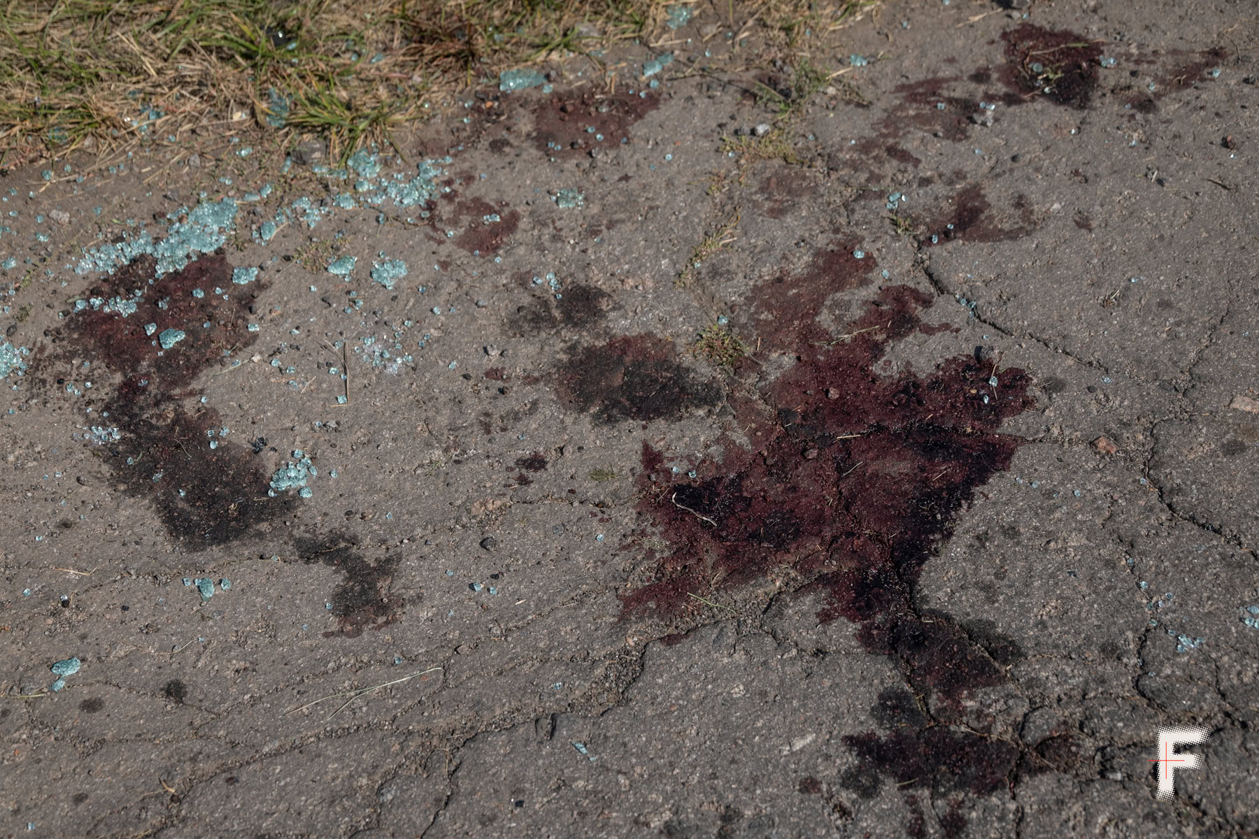 Кров одного з водіїв на землі біля розбитої вантажівки після ракетного удару.