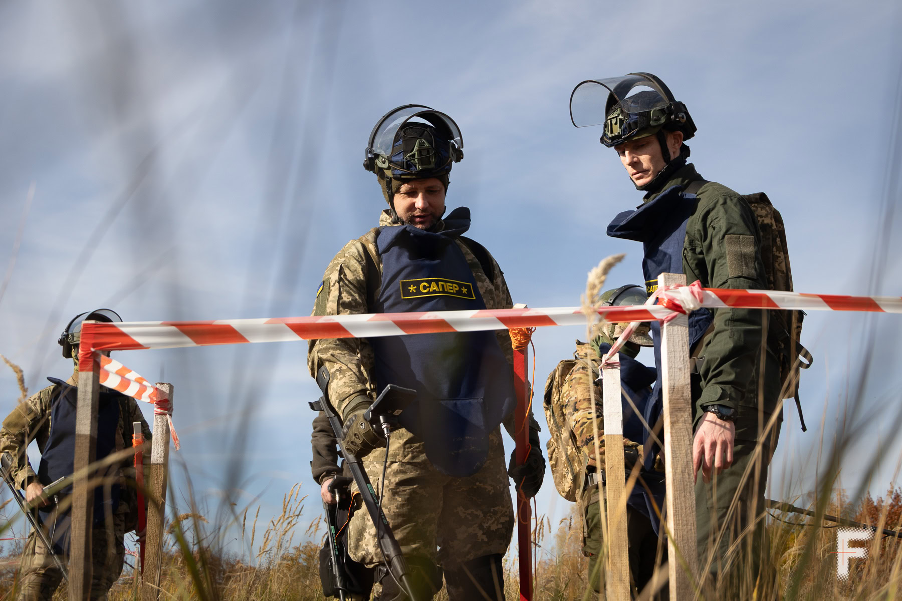 Група саперів оглядає небезпечний периметр у полі