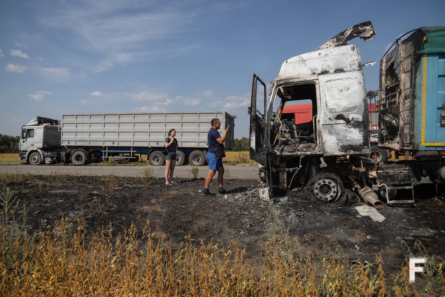 Власник трьох з автомобілів Андрій показує уламок, що влучив у його машину.