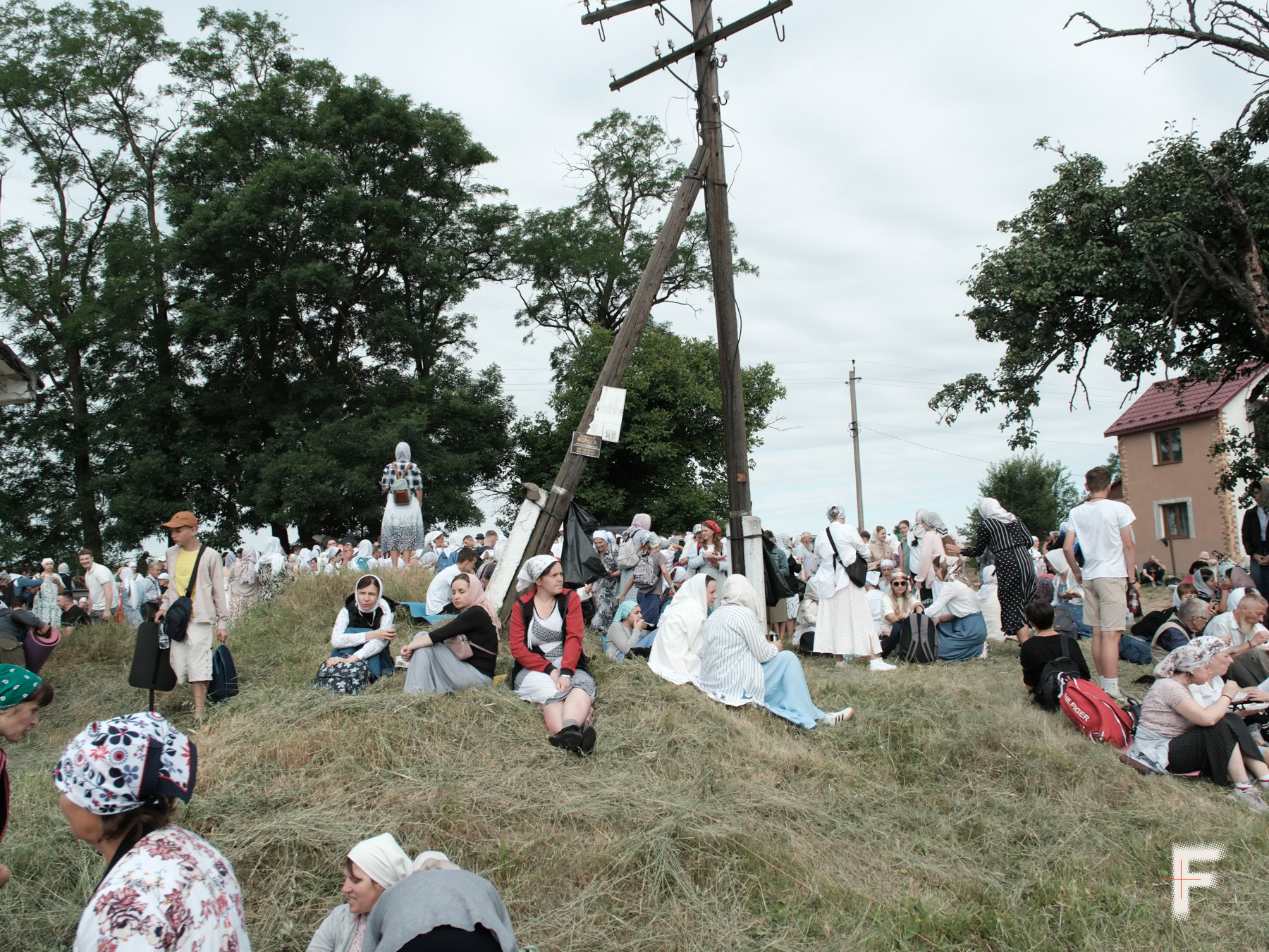 Люди відпочивають на траві під час зупинки хресної ходи, Чернівецька область