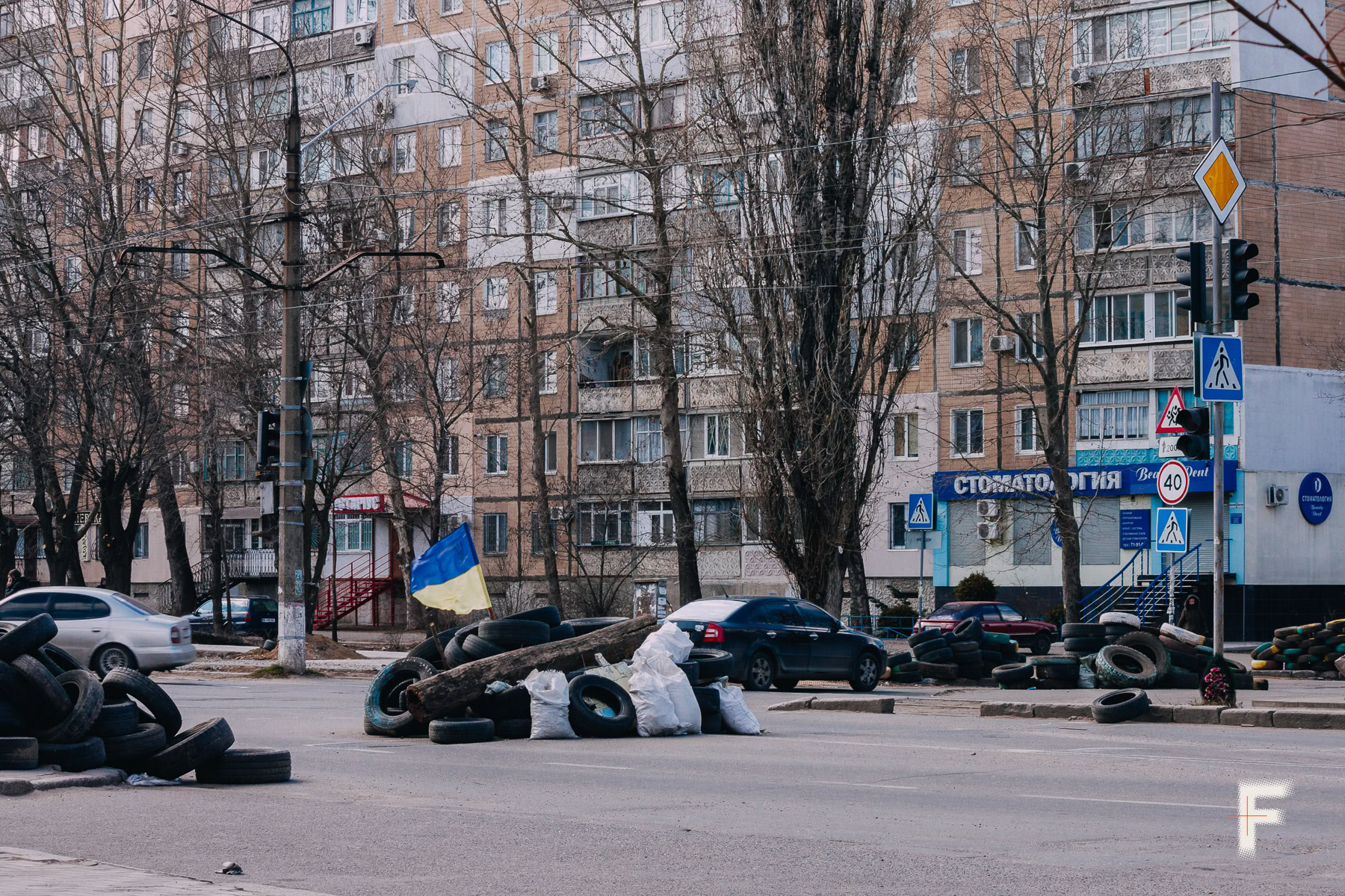 Барикади на міській вулиці з прапором України — символ спротиву та захисту міста.