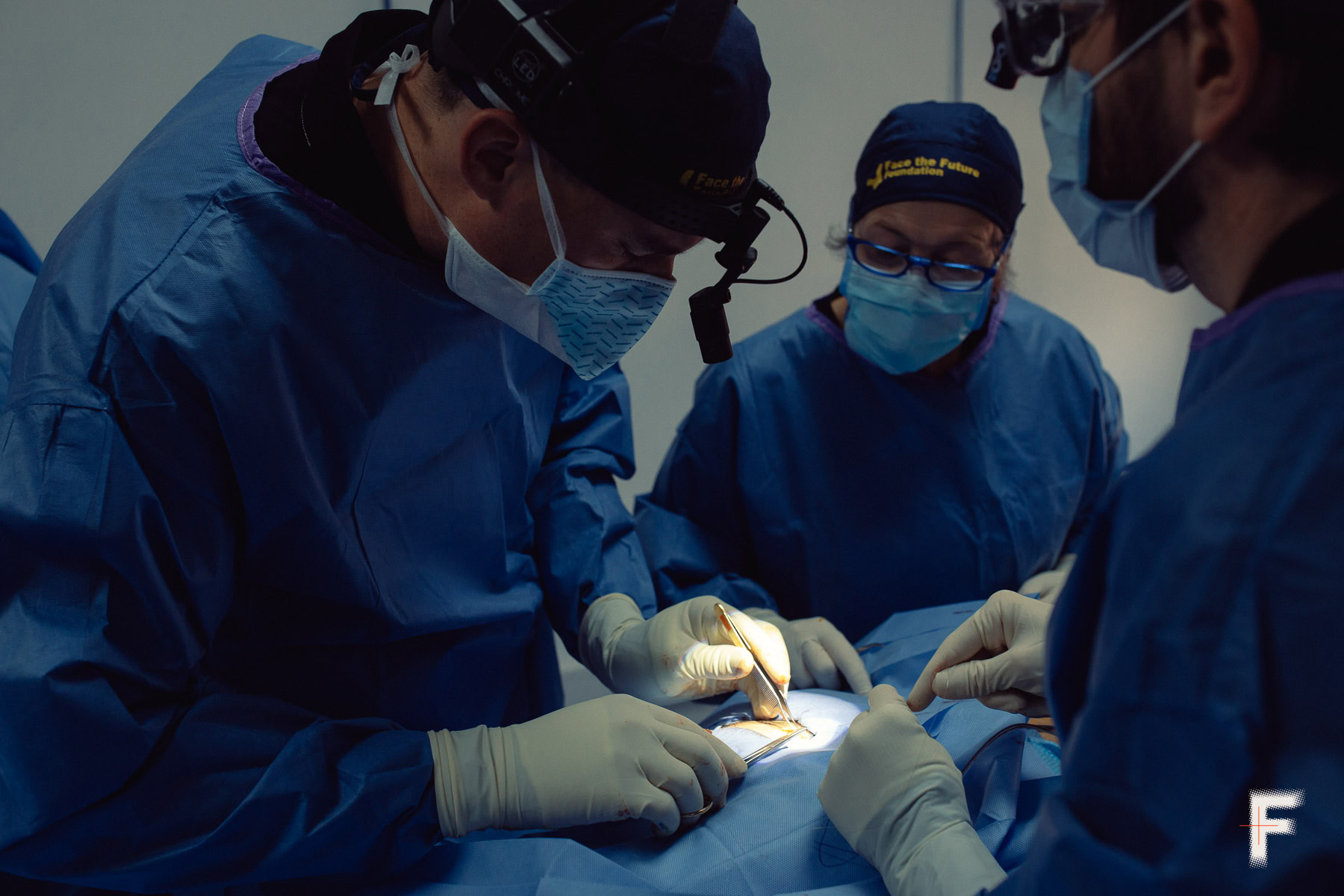 Троє хірургів виконують складну операцію у стерильній операційній.