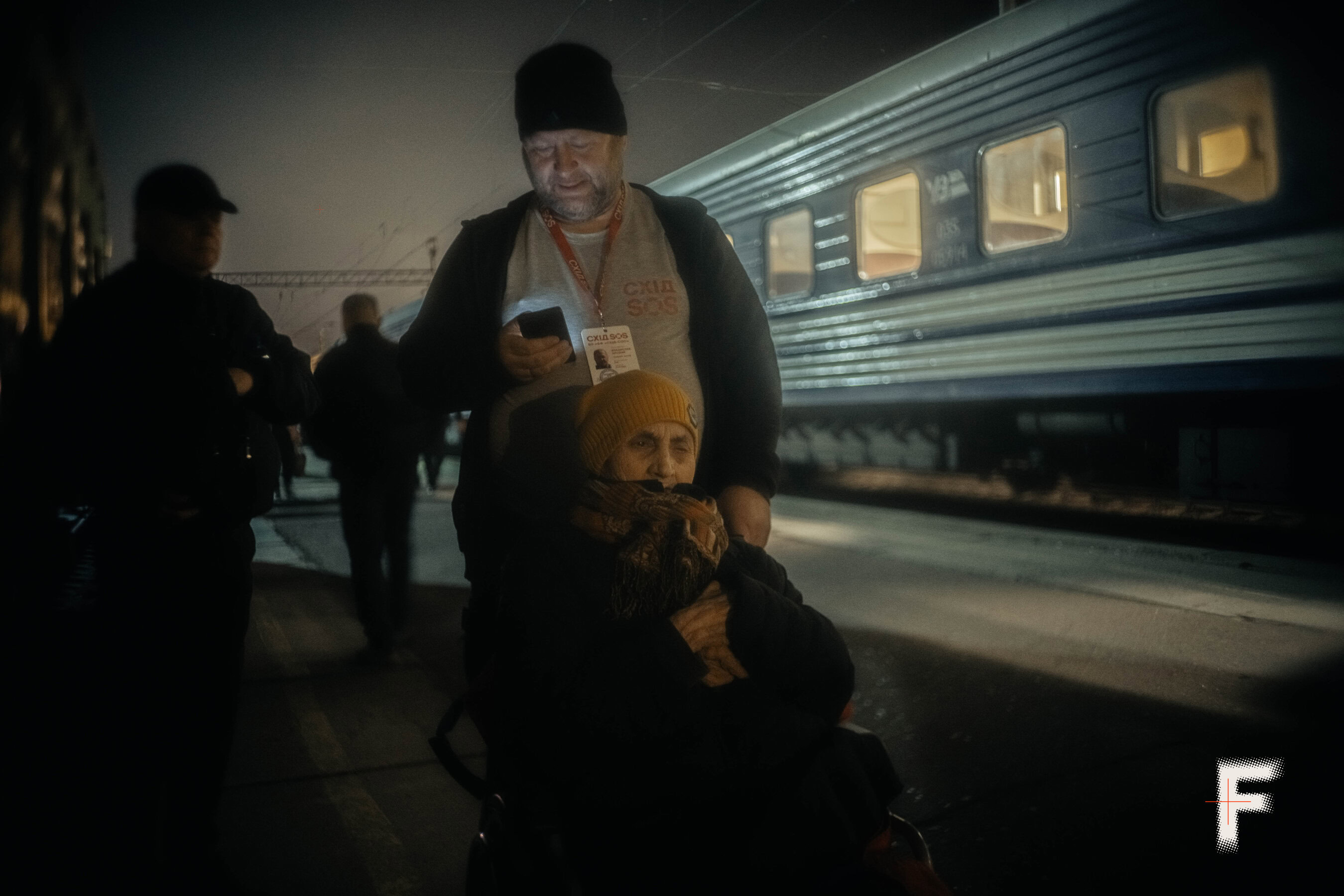 Волонтер «Схід SOS» Владислав Арсеній допомагає маломобільній Любові Іванченко сісти на потяг у Краматорську