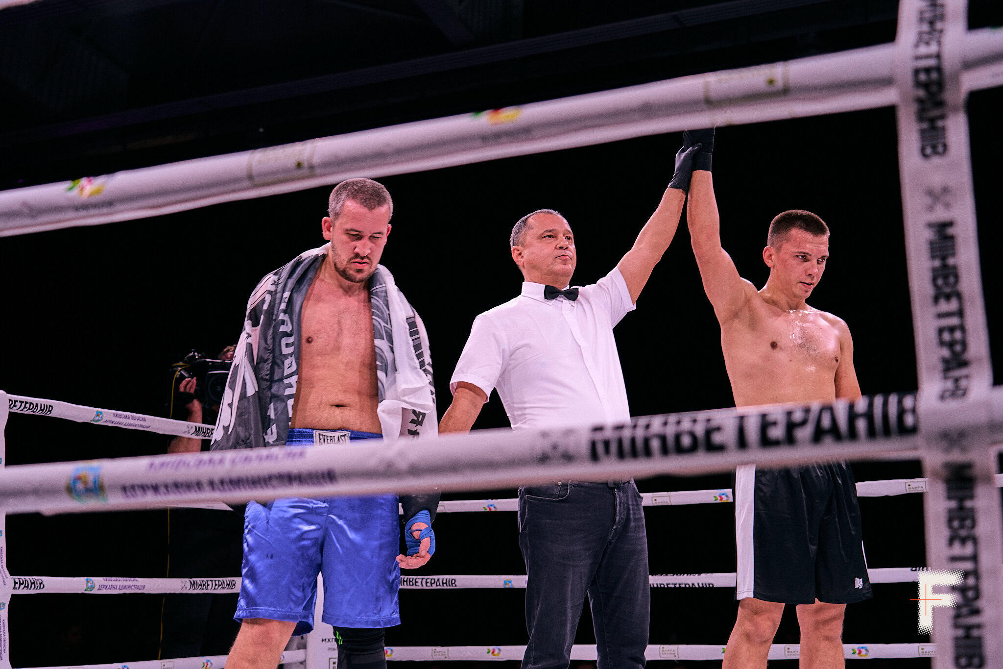 Суддя піднімає руку переможця після завершення боксерського поєдинку серед ветеранів