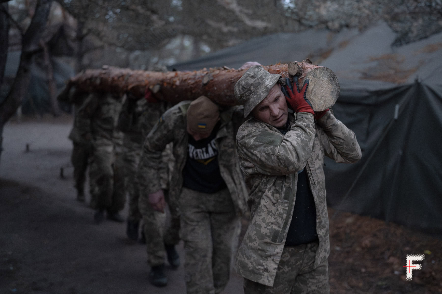 Солдати несуть колоду для спорудження бліндажа в Донецькій області, 11 листопада 2025 року.