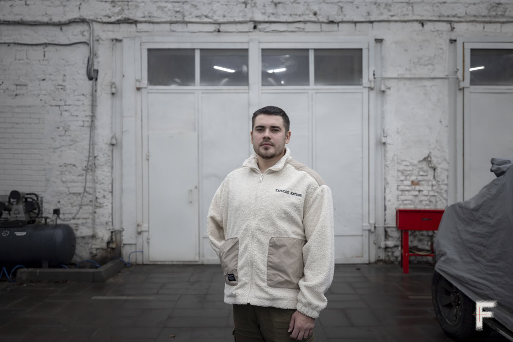 Портрет чоловіка з ампутацією руки в гаражі під час роботи з автомобілями.