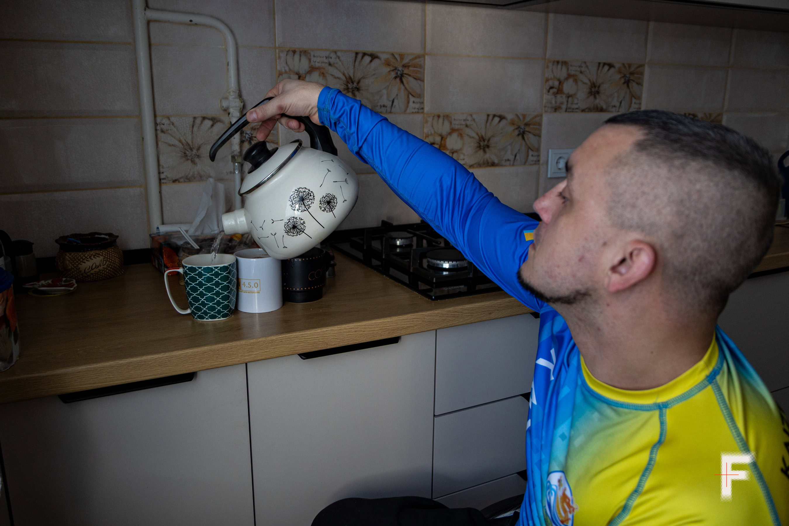 Іван Недобрик наливає гарячу воду у чашки для кави вдома.