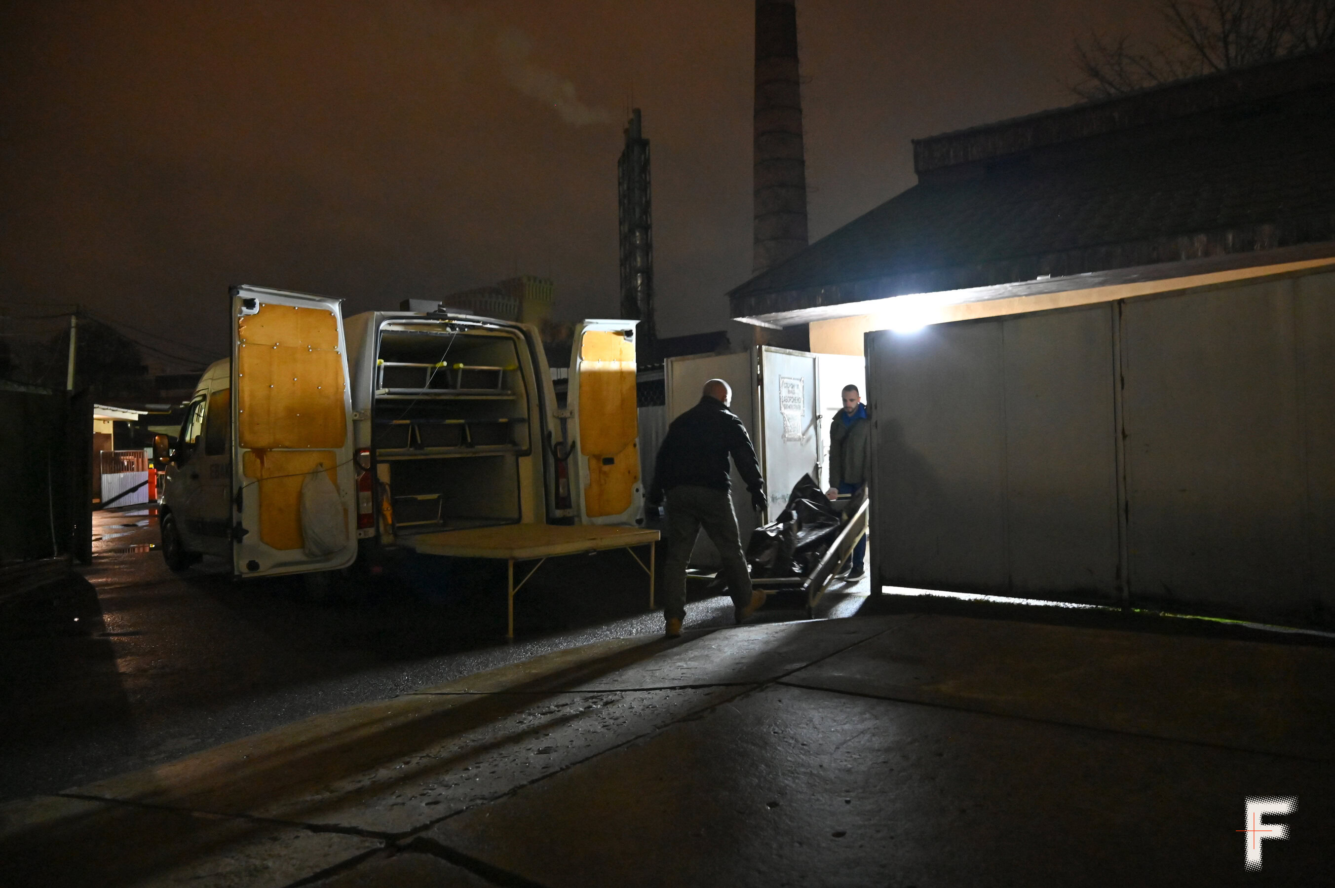 Тіло загиблого українського військового завантажують у мінібус для подальшого прощання.