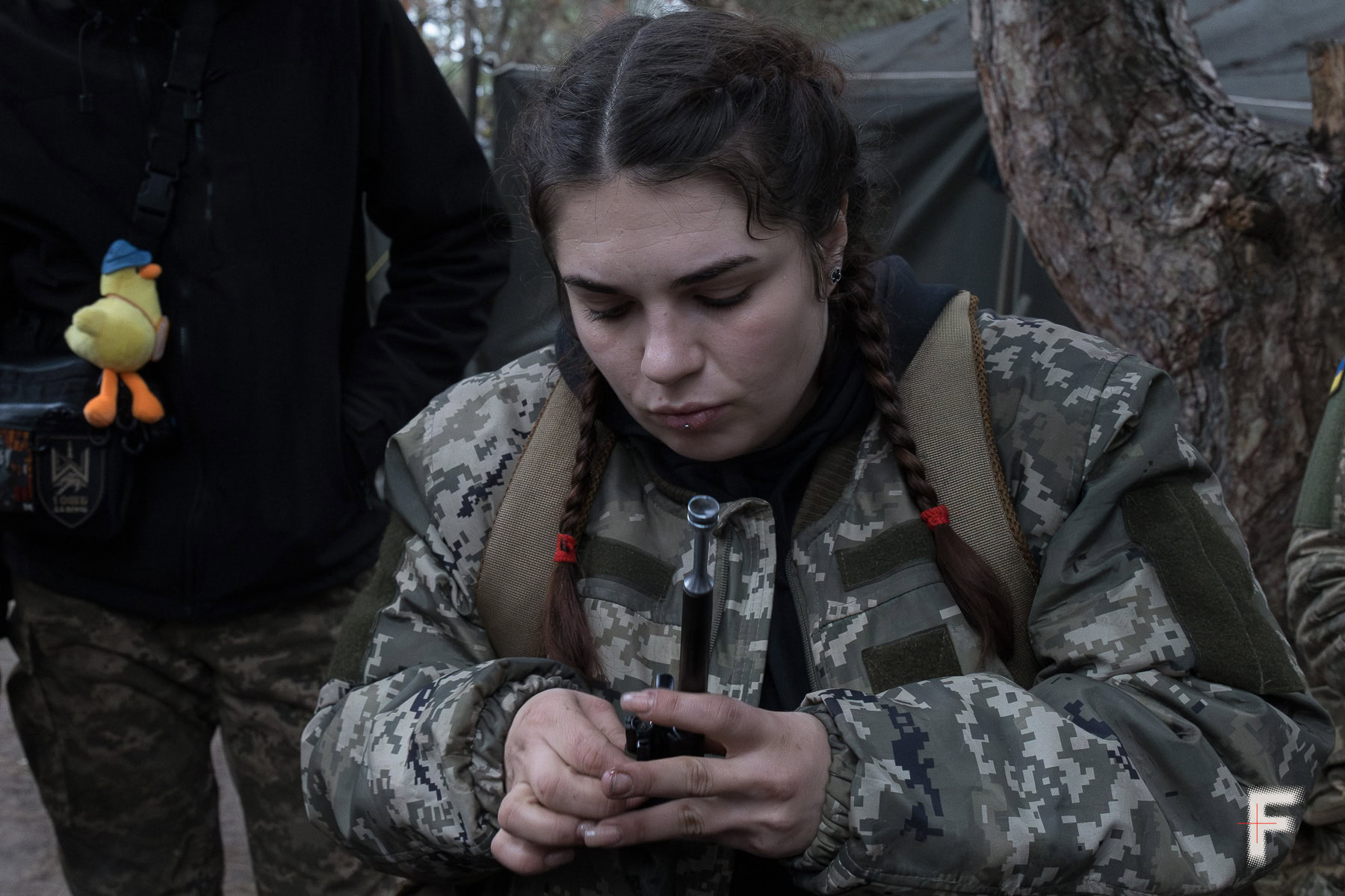 Колишня ув’язнена у військовій формі чистить особисту зброю.