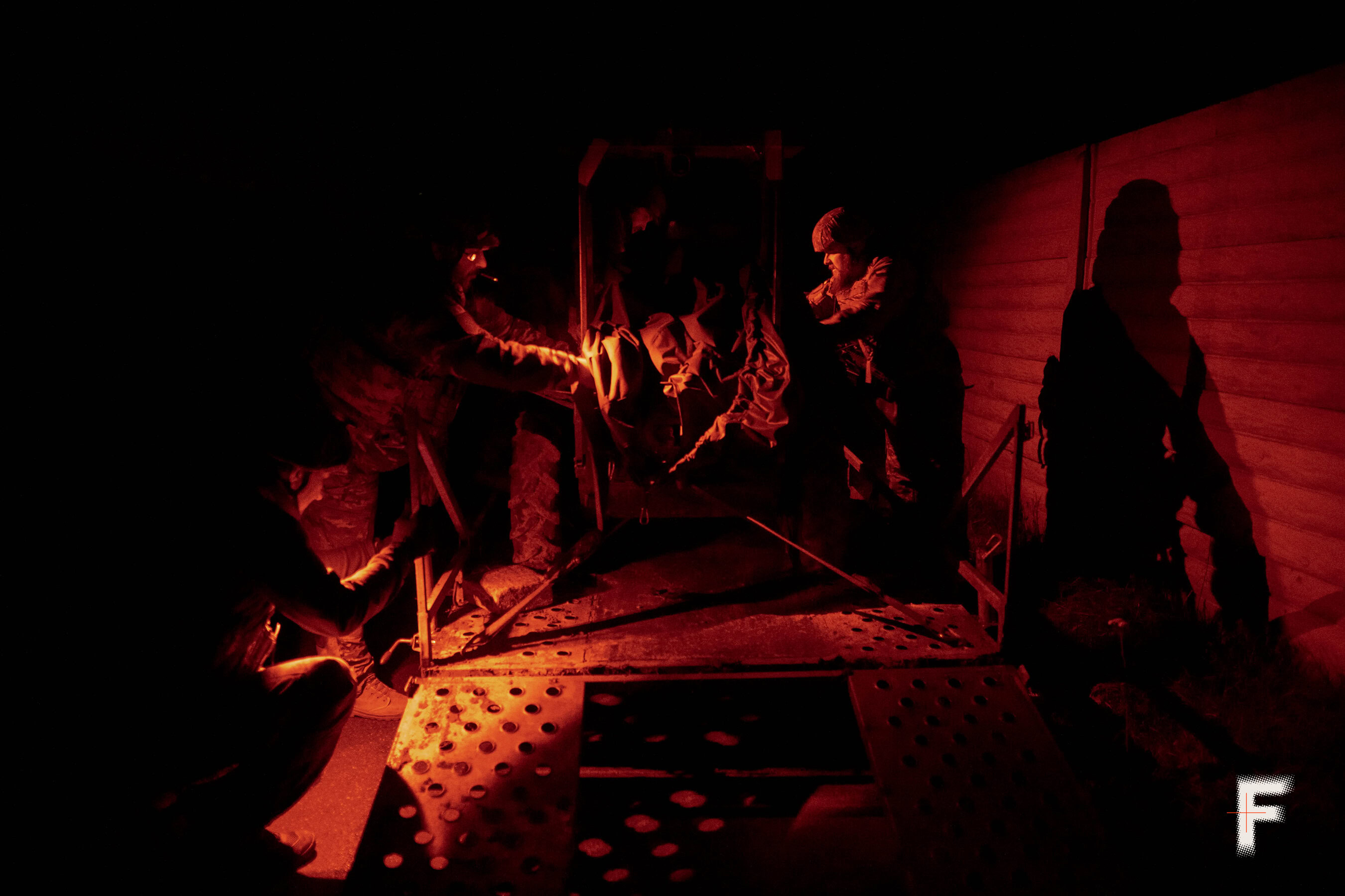 Двоє військових встановлюють наземного робота на транспортний візок.