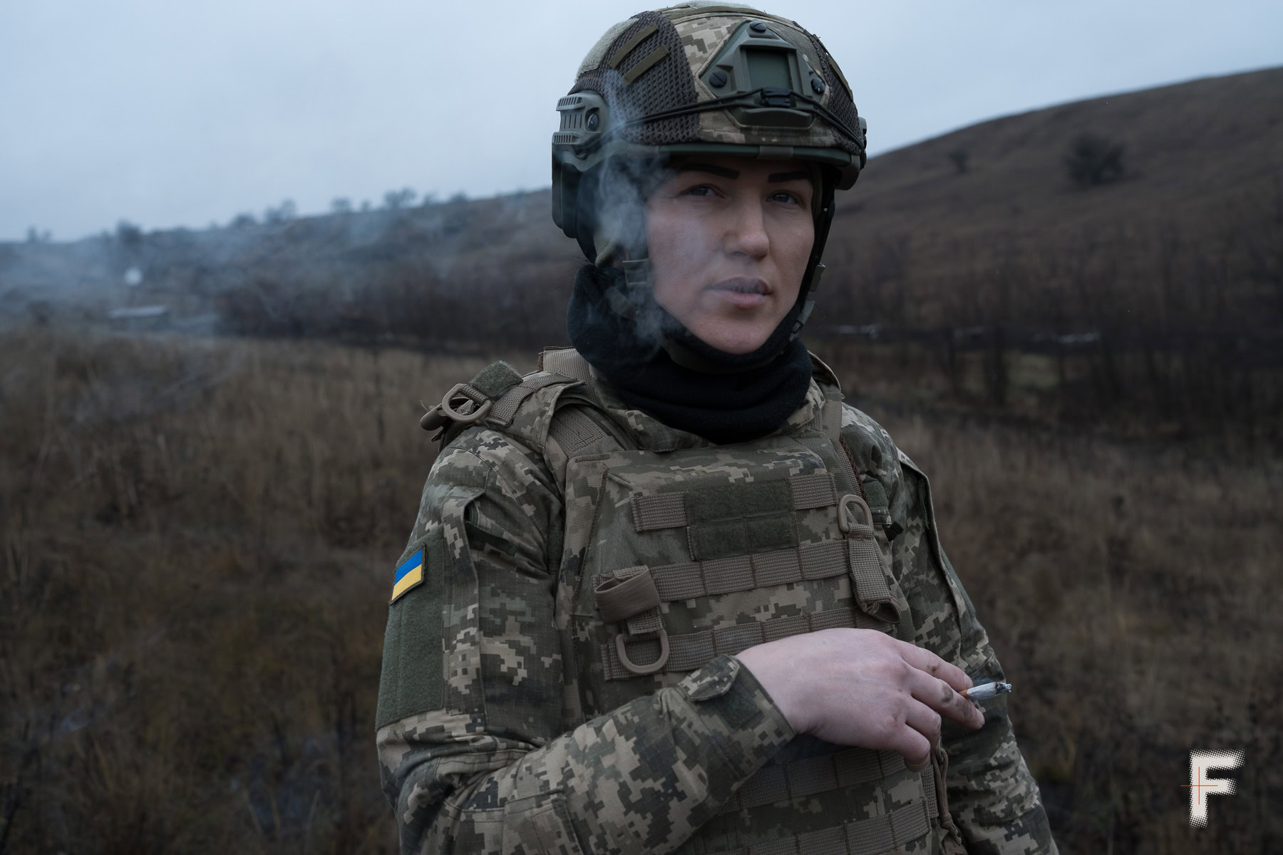 Колишня ув’язнена у військовій формі курить у полі.