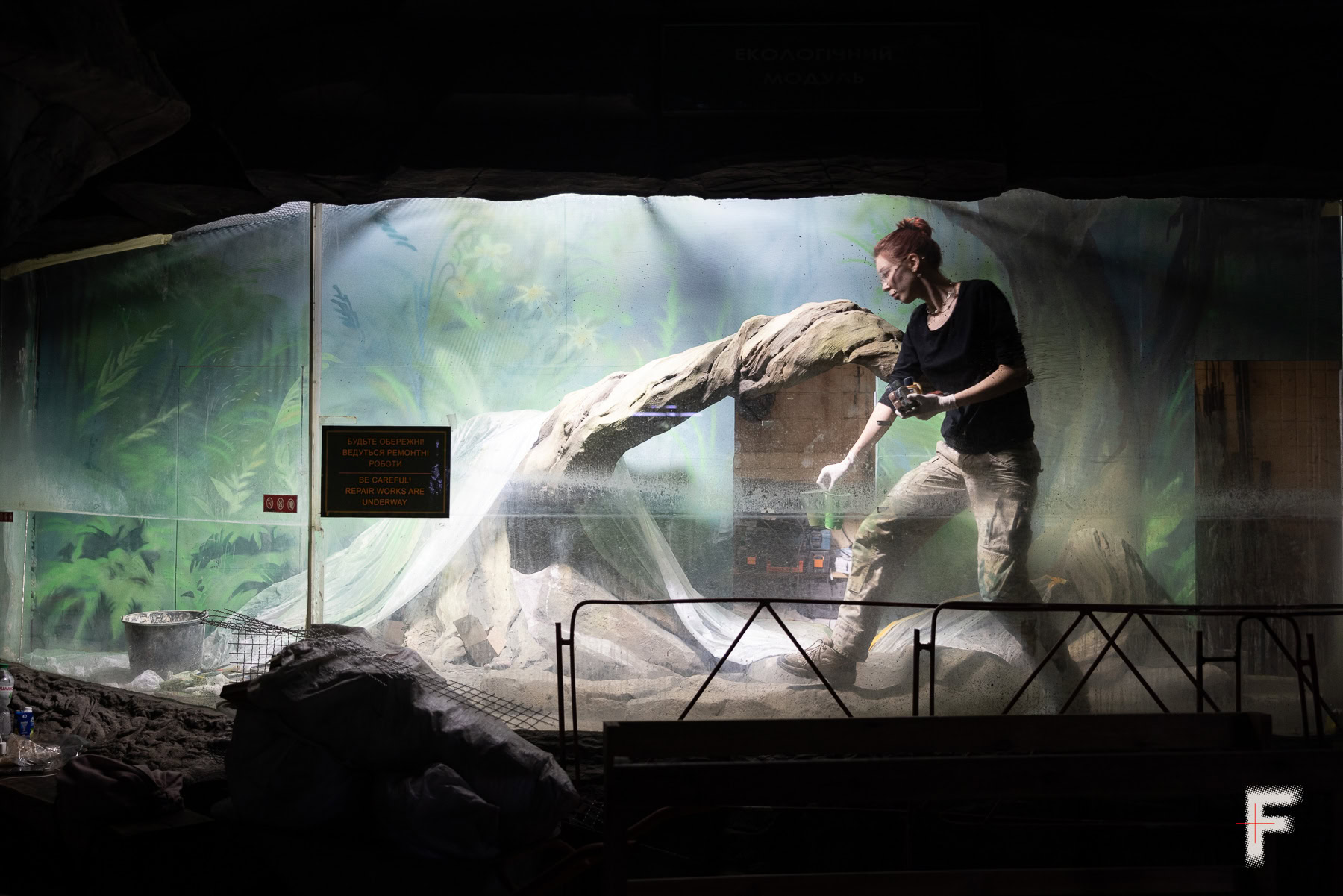 Працівники зоопарку працюють у великому віварії, доглядаючи за тваринами.