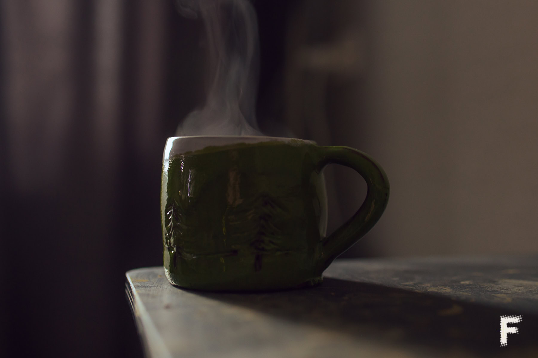 Глиняна чашка з гарячим напоєм, з якої піднімається пара