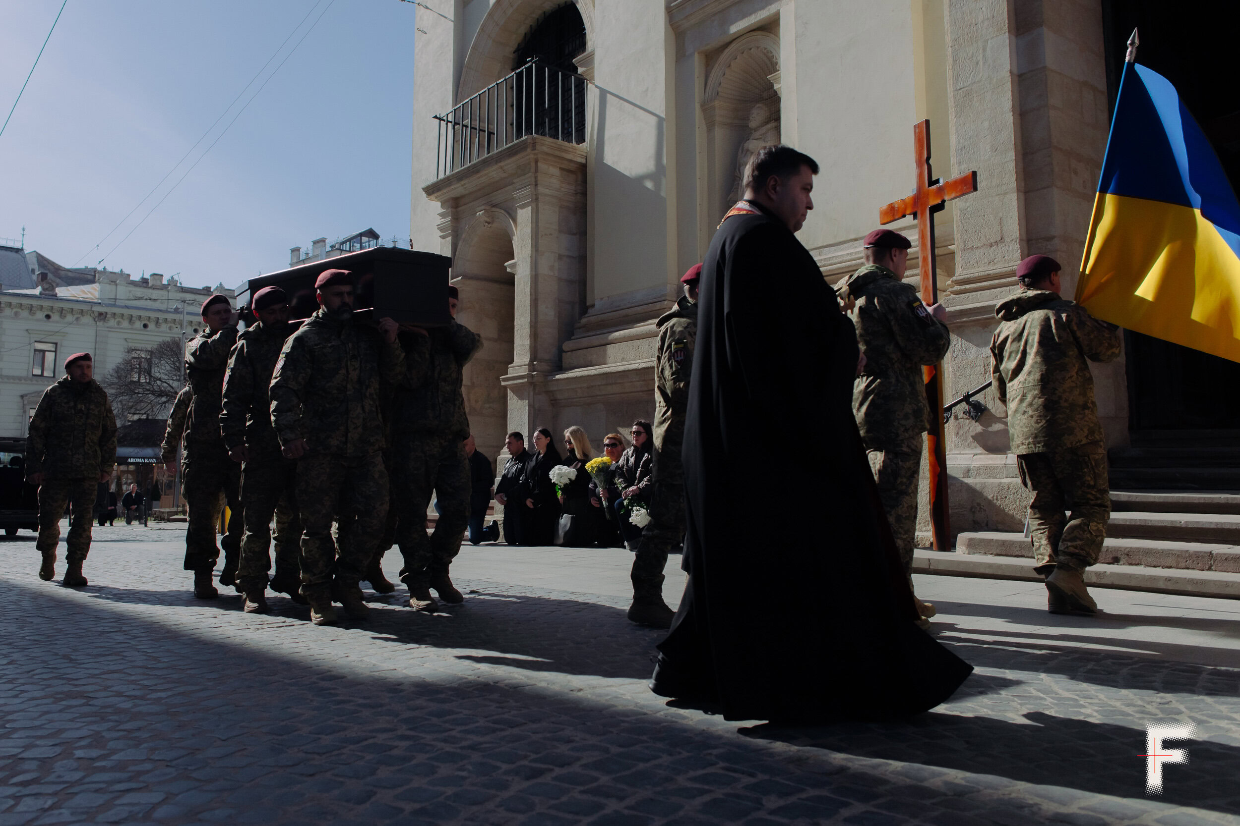 Український прапор несуть військові поруч із труною під час похоронної процесії