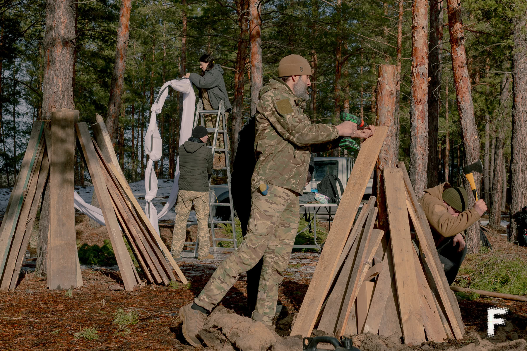 Українські військові готують дрова для великого нічного вогнища в лісі