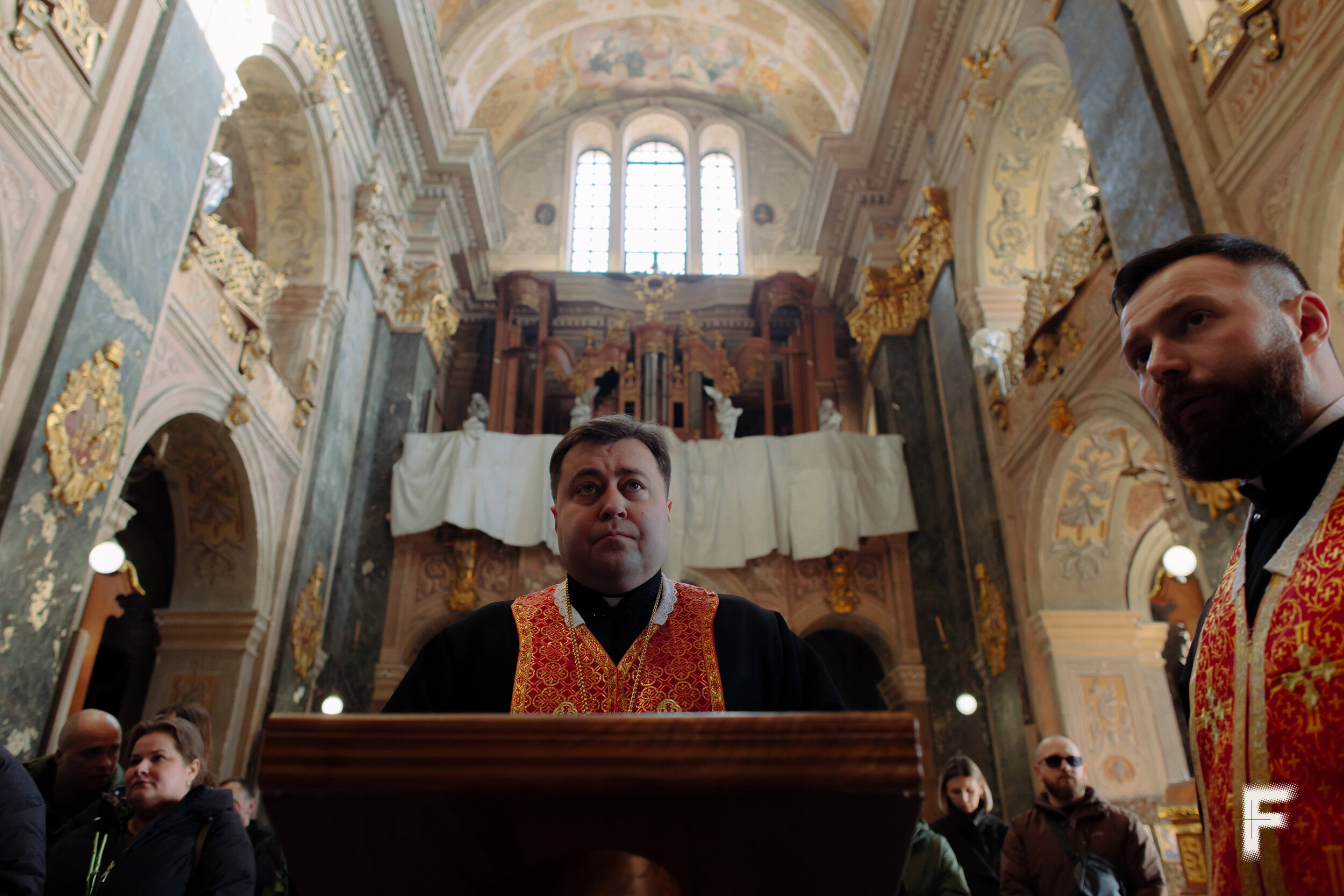 Священник крупним планом стоїть біля пюпітра в церкві під час служби