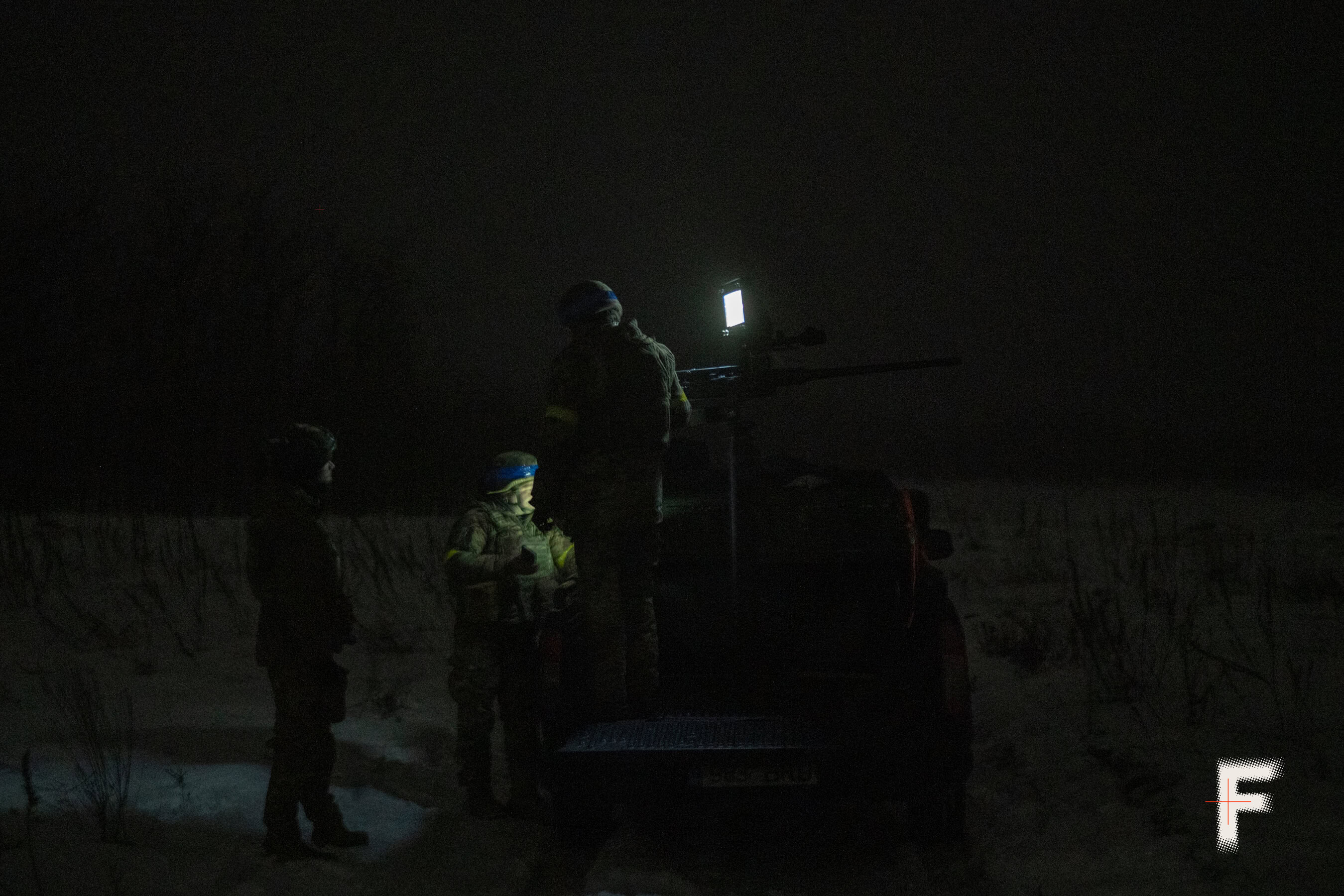 Українські військові кулеметники готують кулемет Browning до нічного бойового чергування.