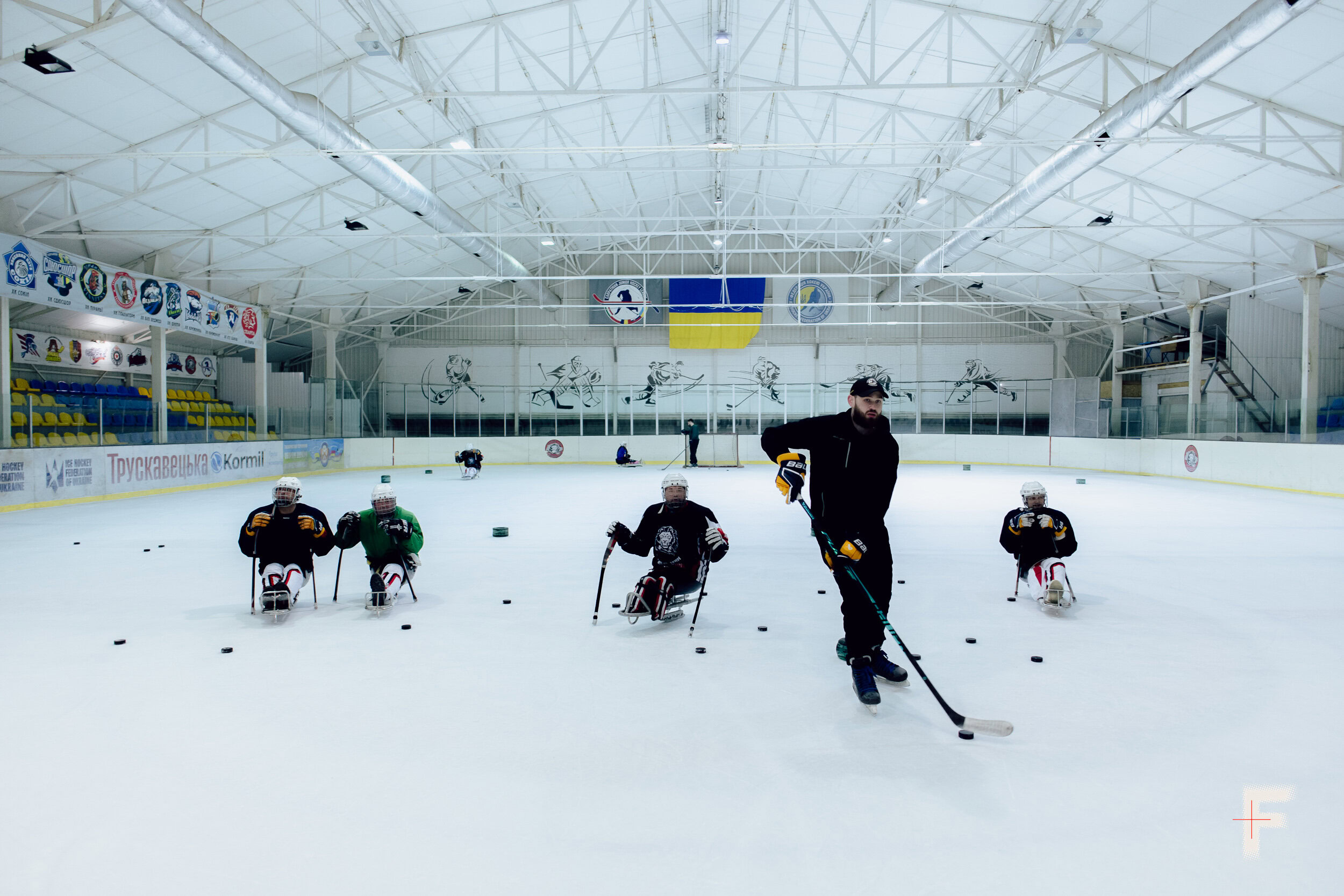 Команда ветеранів-хокеїстів разом із тренером на льодовій арені