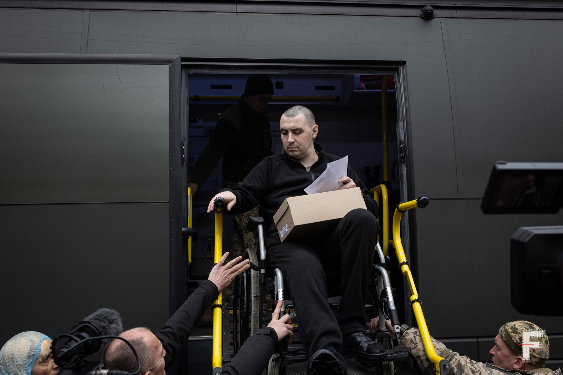 Звільнений військовополонений виходить із автобуса на інвалідному візку після обміну, Україна, квітень 2026