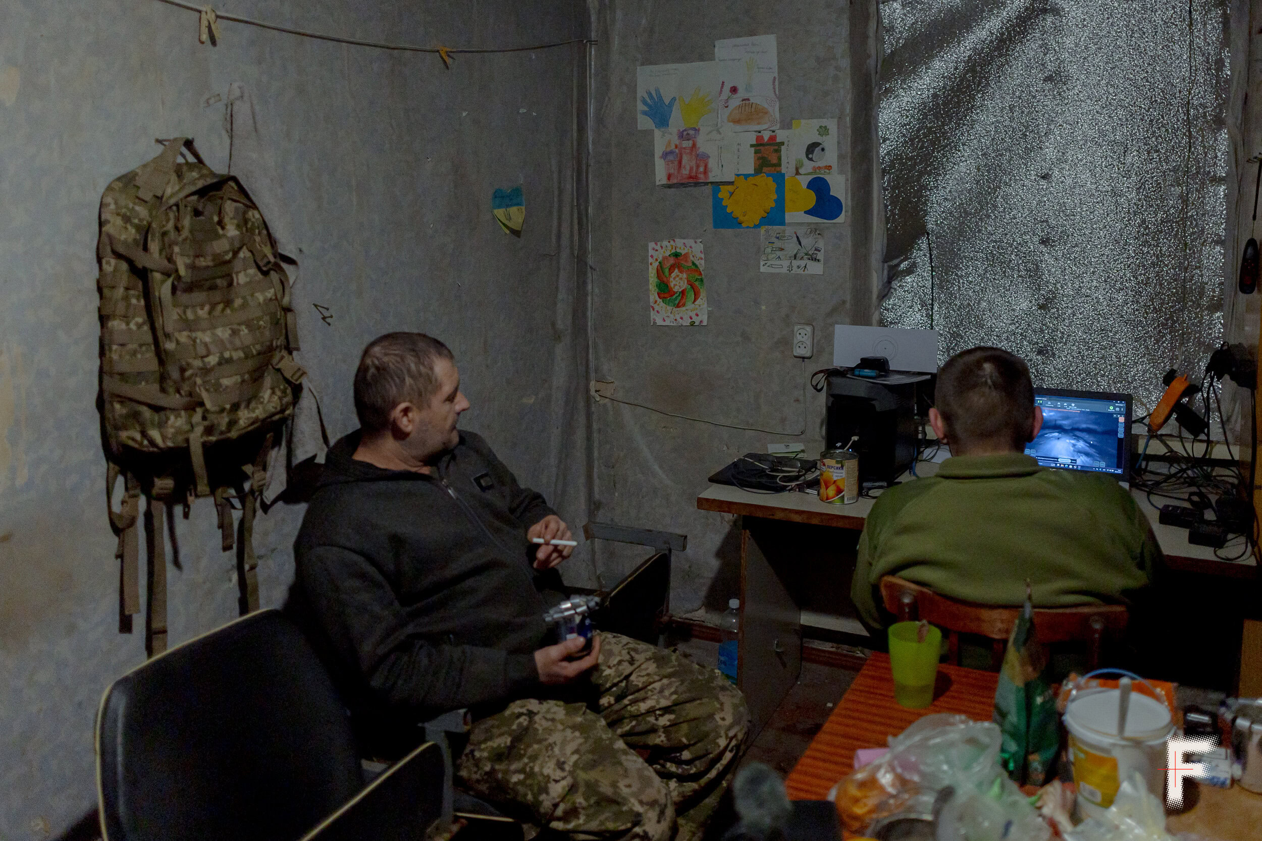 Українські військові в камуфляжі оглядають і ремонтують наземний роботизований пристрій (UGV)