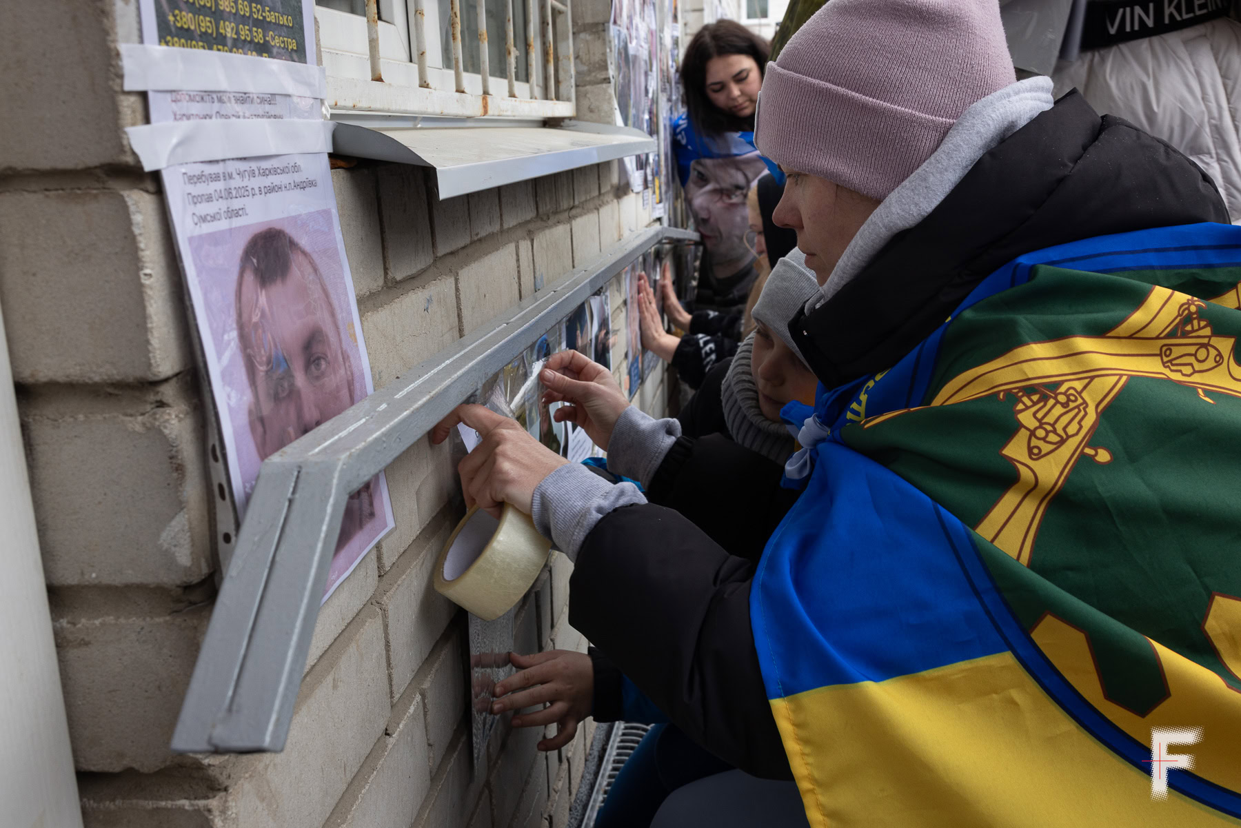 Жінка тримає портрет близької людини, яка перебуває в російському полоні, Україна, 2026