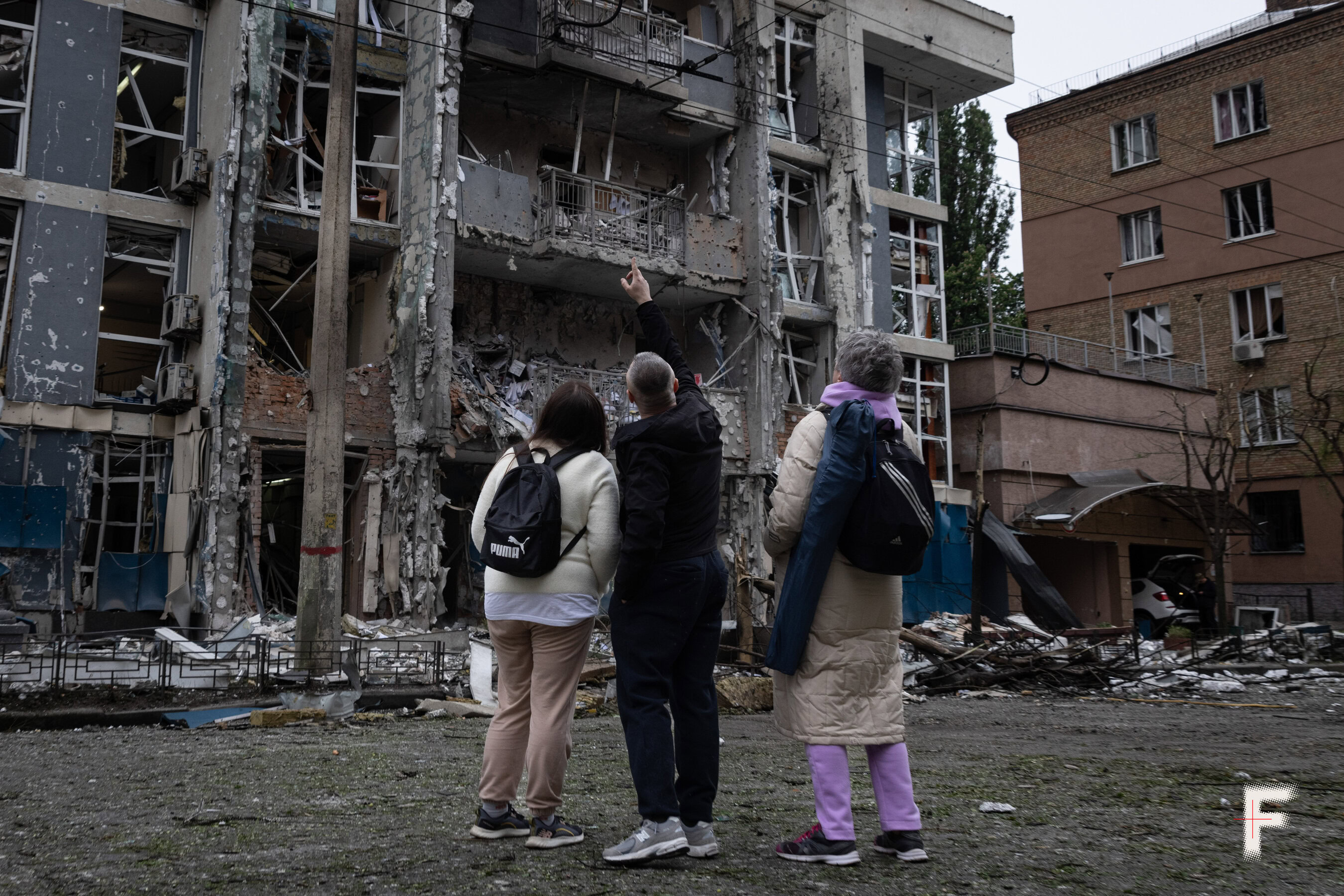 Люди роздивляються наслідки влучання ударного дрону у цивільний будинок