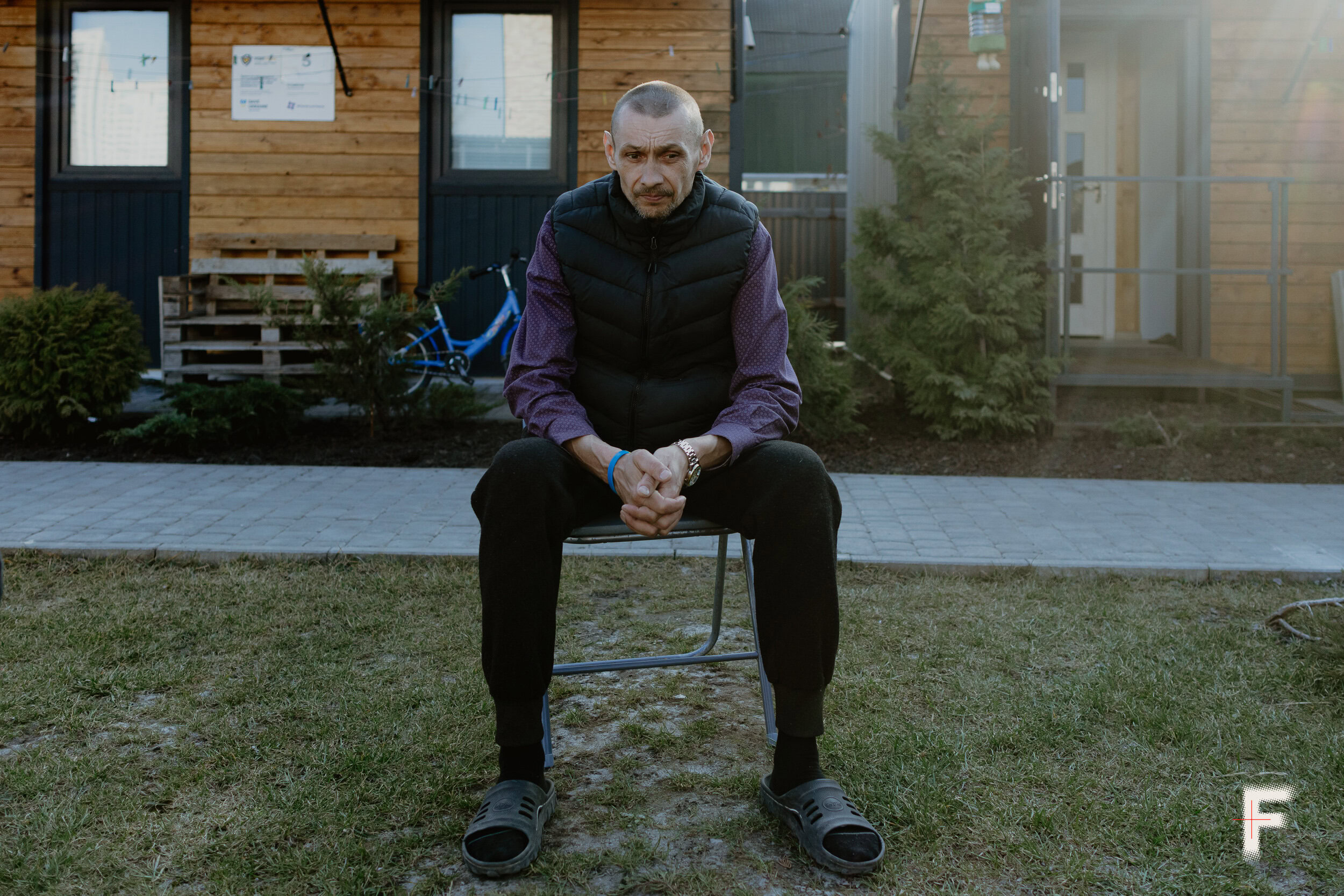 Чоловік сидить із схрещеними руками та дивиться вниз, емоційний стан під час війни, Україна, 2026
