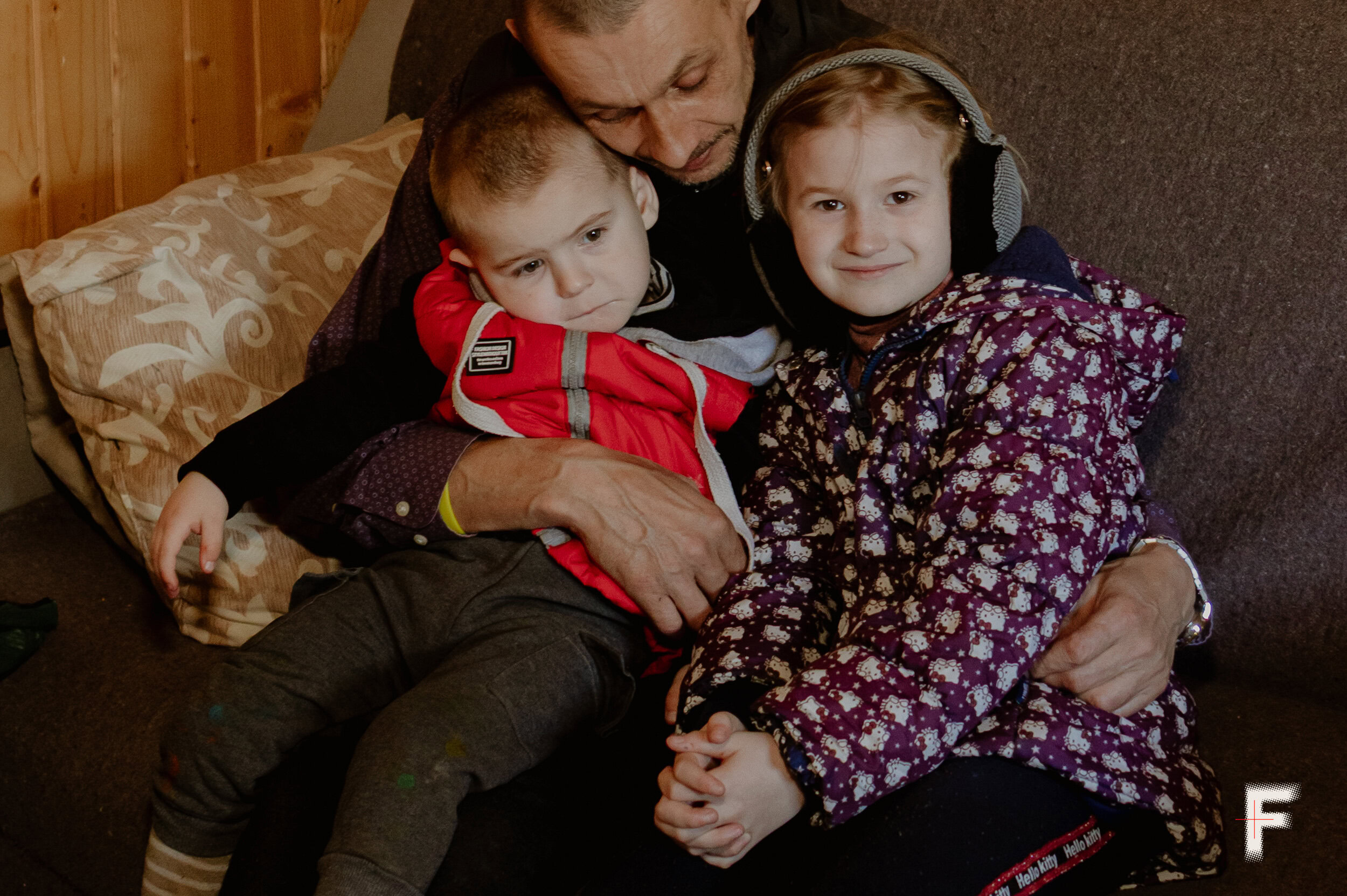 Чоловік тримає на руках двох дітей — сина і доньку, родина в умовах війни, Україна, 2026