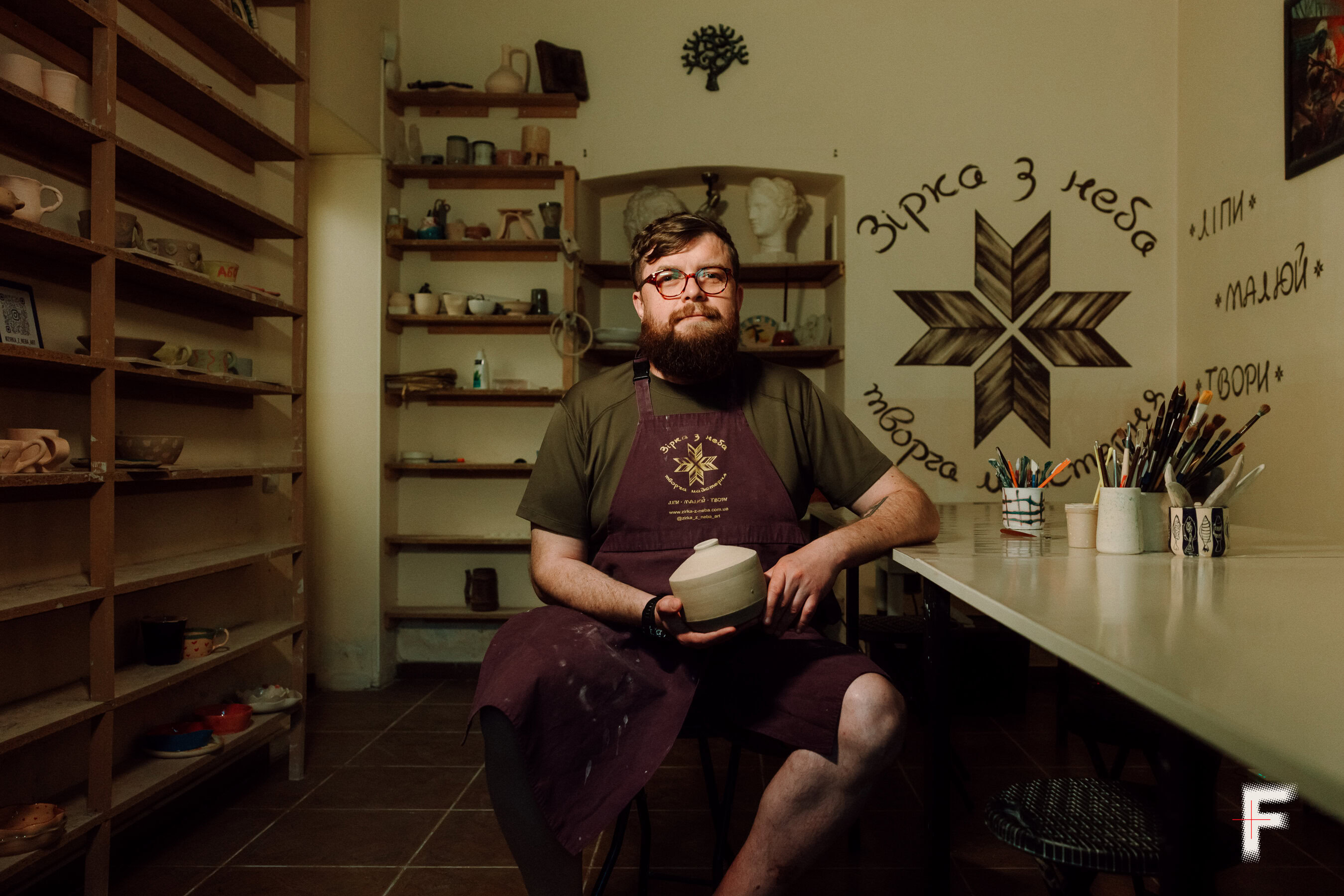 Портрет майстра кераміки, який сидить у своїй творчій майстерні.