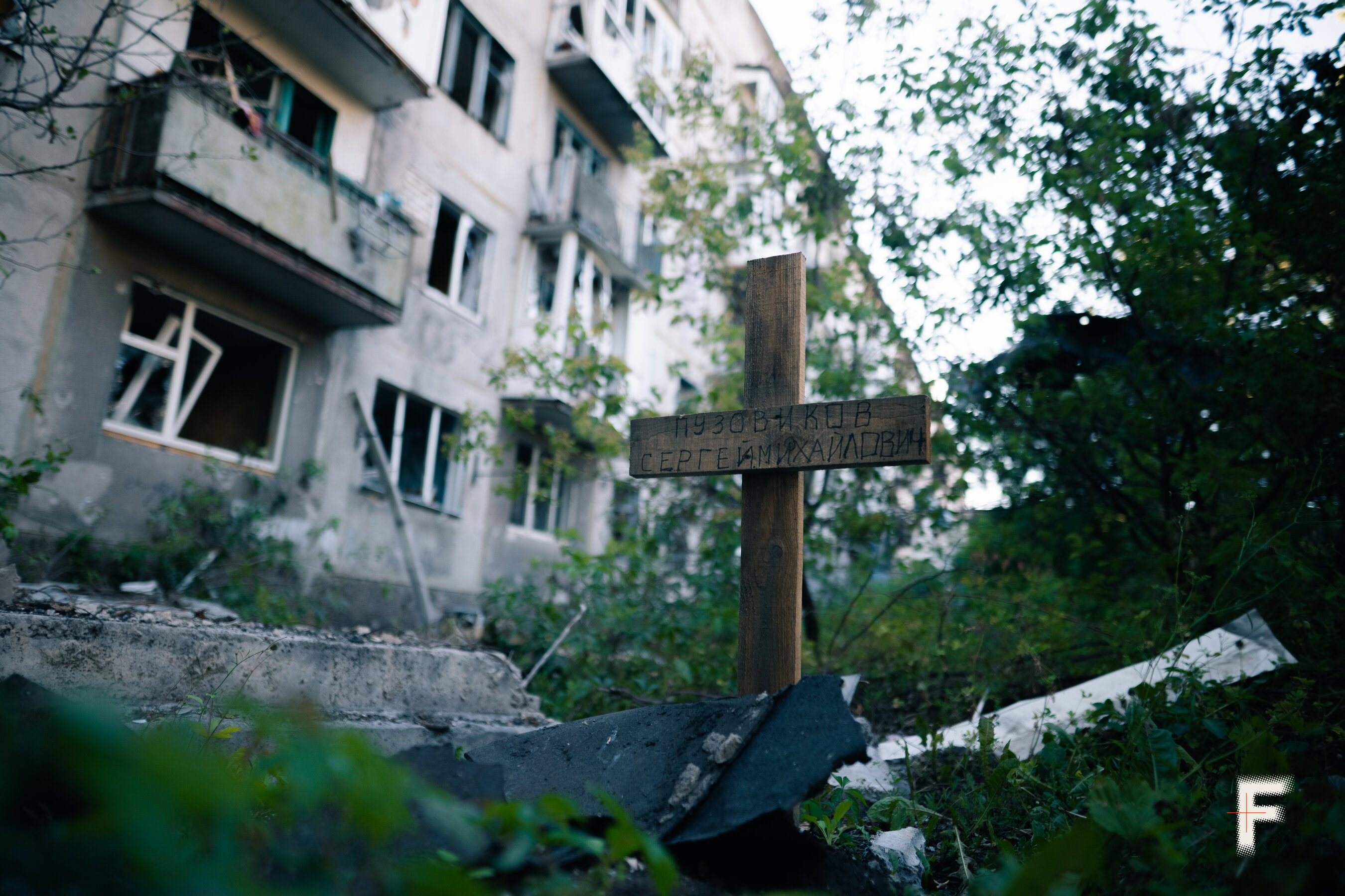 Свіжа могила загиблого цивільного облаштована на подвір'ї серед житлових будинків у Добропіллі.