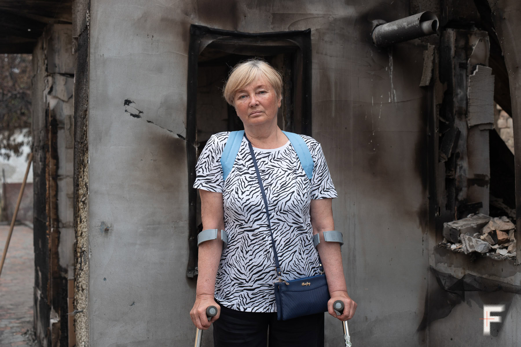 Людмила Іщенко стоїть на подвір'ї свого будинку у Вишневому, який постраждав під час нічної детонації боєприпасів.