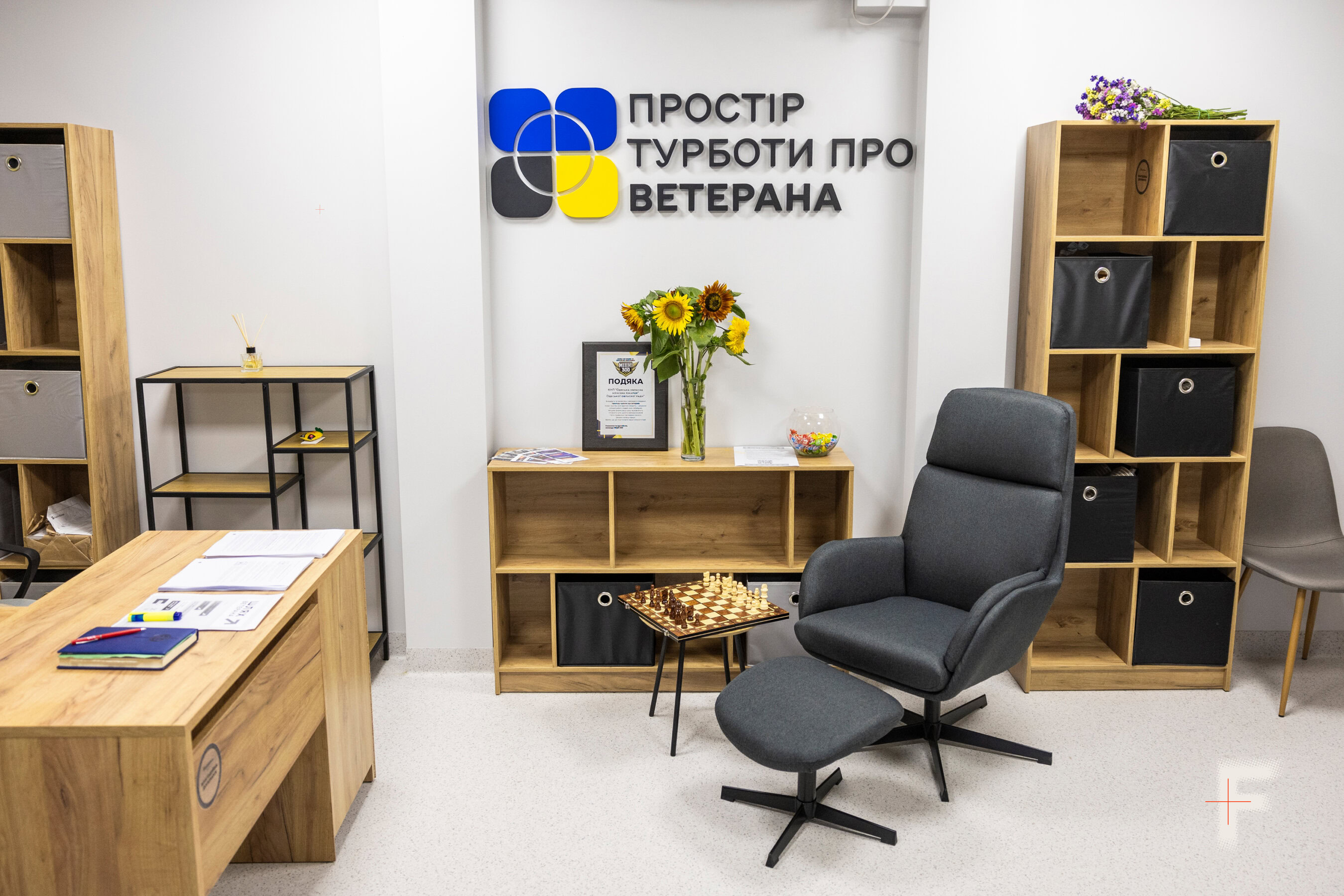Затишний куточок «Простору турботи» для ветеранів і ветеранок з м'якими кріслами та шаховою дошкою в коридорі лікарні.