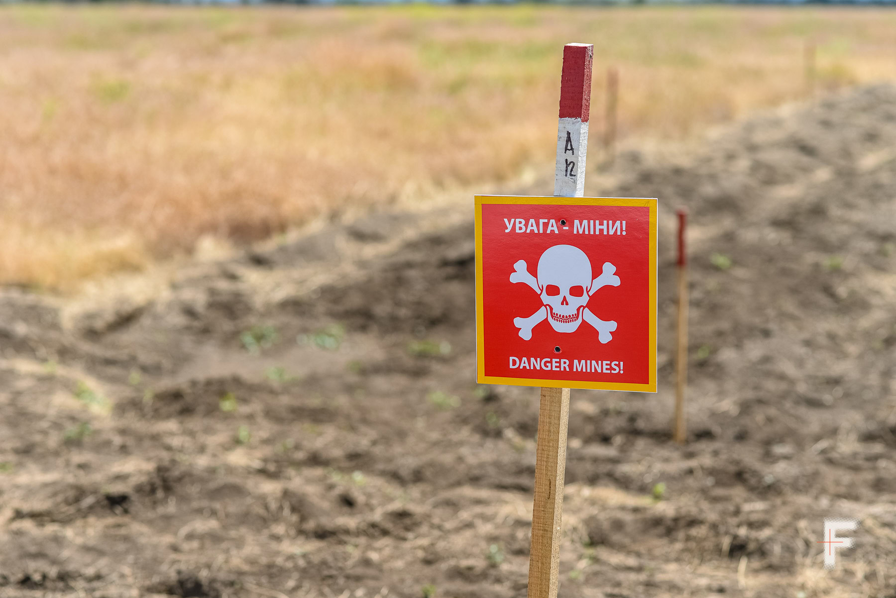 Попереджувальний знак «Увага – міни!» стоїть на межі замінованої ділянки поля в Миколаївській області.