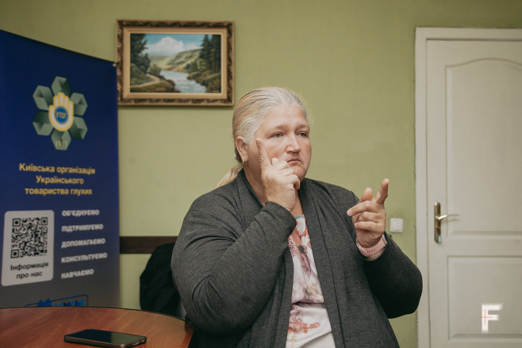 Зінаїда Козаченко розповідає про життя нечуючої родини під час інтервʼю в офісі УТОГ.