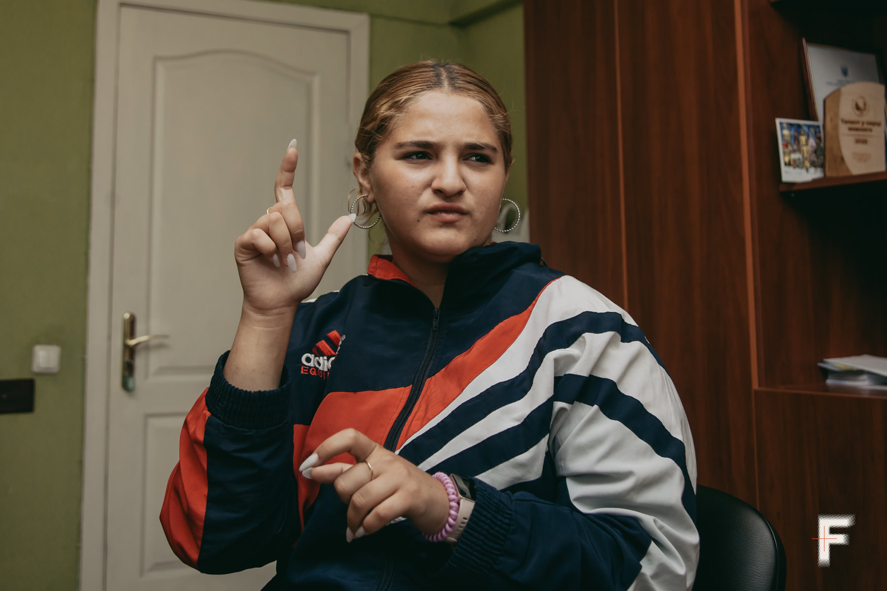 Рита Козаченко розповідає жестами, як виглядав їхній будинок після обстрілу.