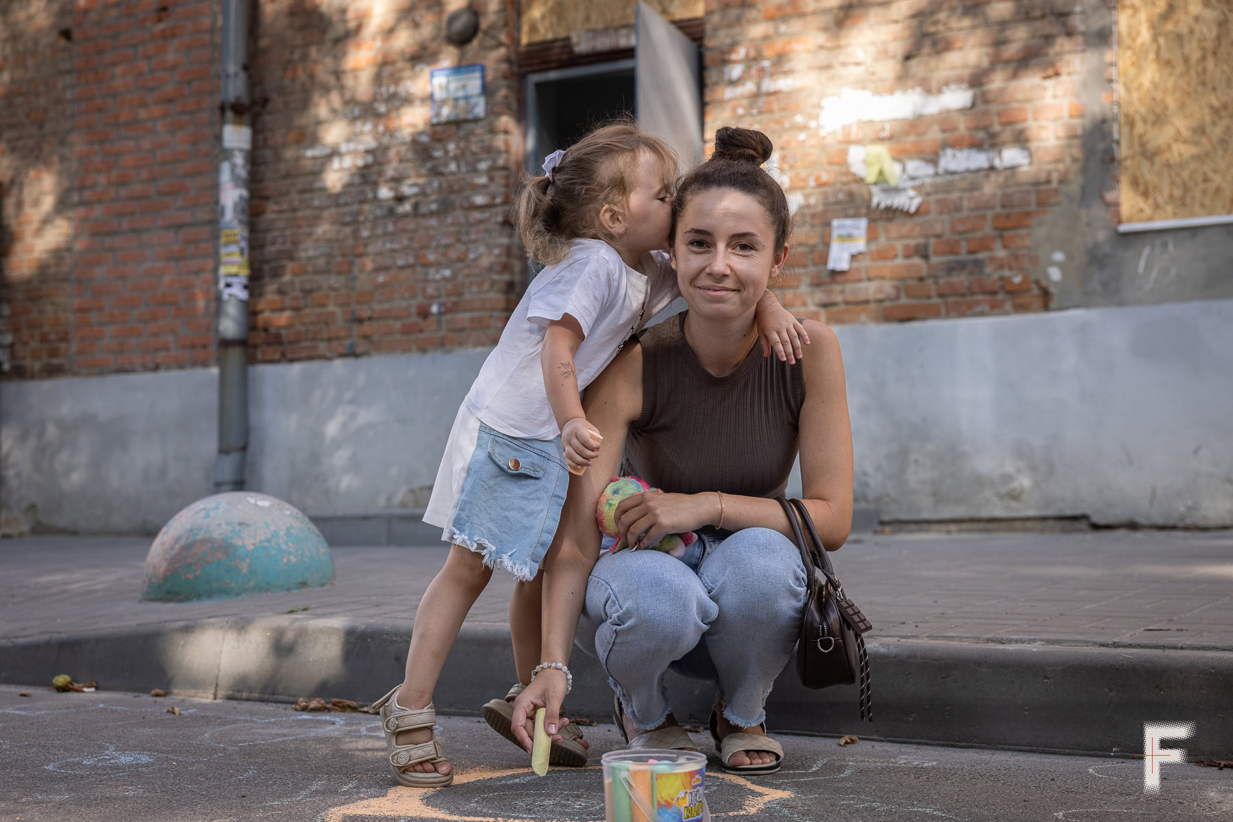 Христина Голод з донькою Кірою біля будинку на вулиці Тараса Шевченка, пошкодженого ударом КАБа в Сумах.